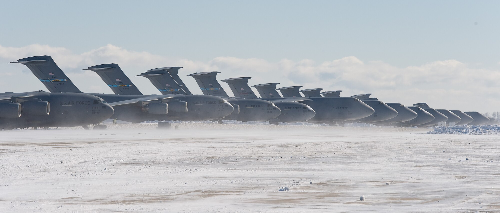 C-17A Globemaster III and C-5M Super Galaxy aircraft sit on the frozen flight line Jan. 22, 2014, at Dover Air Force Base, Del. The base received six inches of snow from the second major snow storm to hit the area. (U.S. Air Force photo/Roland Balik)