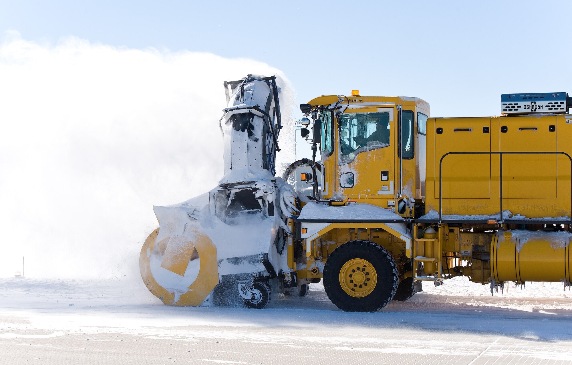 A snow blower from the 436th Civil Engineer Squadron blows snow off the runway Jan. 22, 2014, at Dover Air Force Base, Del. Snow removal crews worked 12-hour shifts to remove snow and ice that accumulated on the two runways, numerous taxiways and the flight line. (U.S. Air Force photo/Roland Balik)