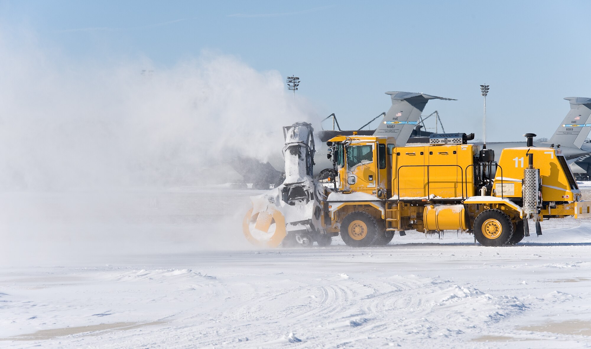 A snow blower from the 436th Civil Engineer Squadron clears a snowdrift from the taxiway Jan. 22, 2014, at Dover Air Force Base, Del. As the wind-driven snow fell and even after, the base continued normal operations as Team Dover personnel initiated snow removal throughout the base. (U.S. Air Force photo/Roland Balik)