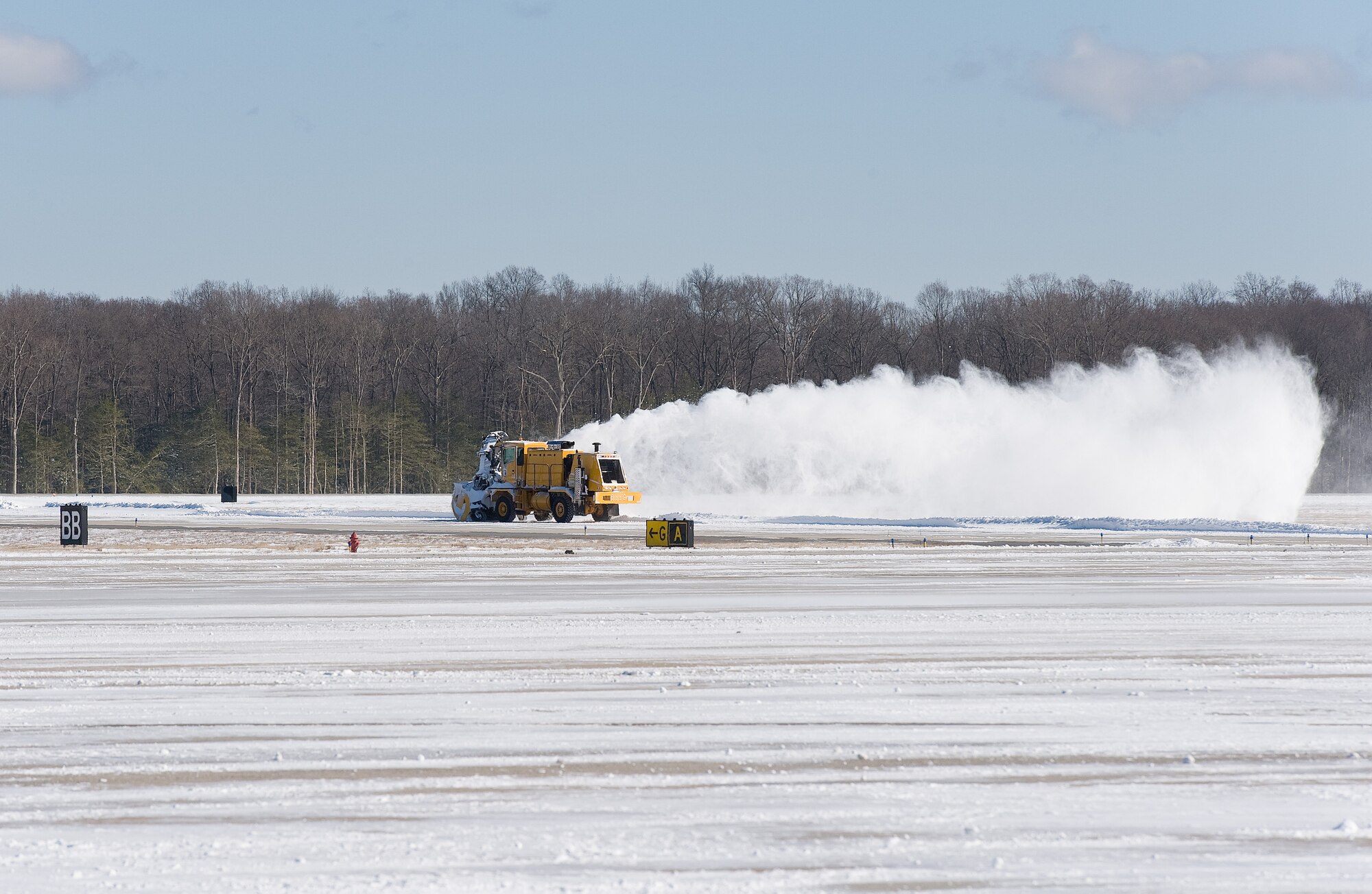 A snow blower from the 436th Civil Engineer Squadron clears snow from the taxiway Jan. 22, 2014, at Dover Air Force Base, Del. Snow removal crews cleared six inches of snow from two runways, numerous taxiways and the flight line to keep the mission moving. (U.S. Air Force photo/Roland Balik)