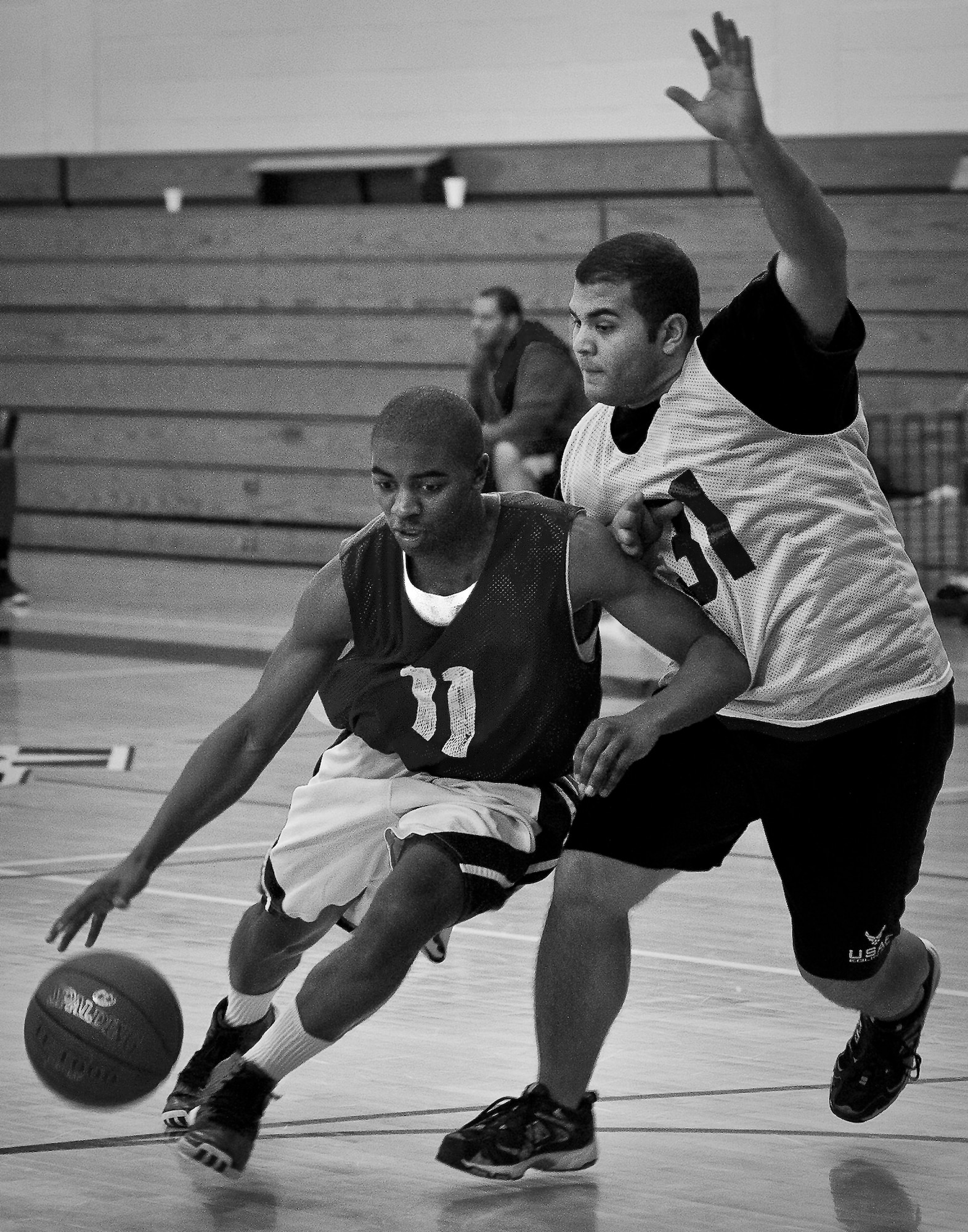 A player dribbles past a defender during a 3-on-3 basketball tournament held Jan. 24 at the Eglin Air Force Base, Fla., gym.  A total of six teams battled it out in 10-minute games in the double elimination tournament.  (U.S. Air Force photo/Samuel King Jr.)