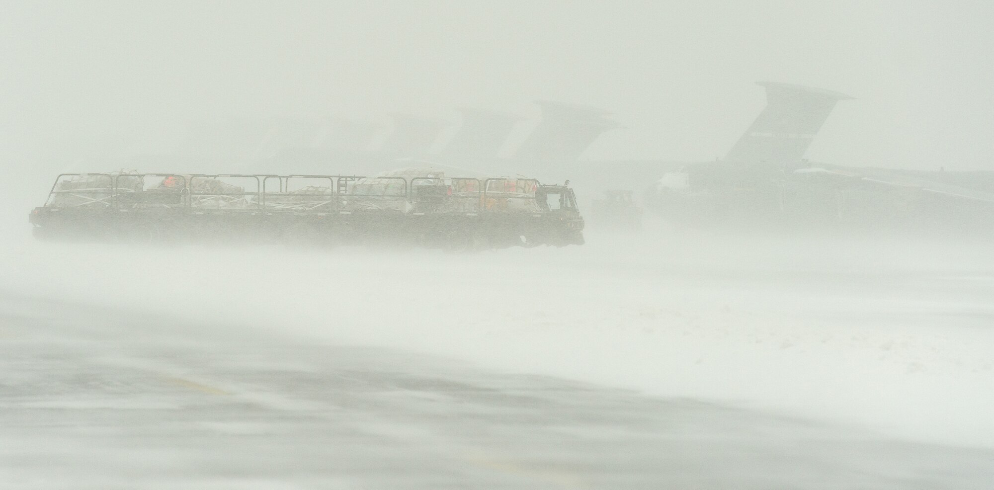 A K-loader from the 436th Aerial Port Squadron makes its way to an aircraft  Jan. 21, 2014, at Dover Air Force Base, Del. Despite inclement weather conditions, aerial porters and equipment kept cargo and the mission moving. (U.S. Air Force photo/Roland Balik)