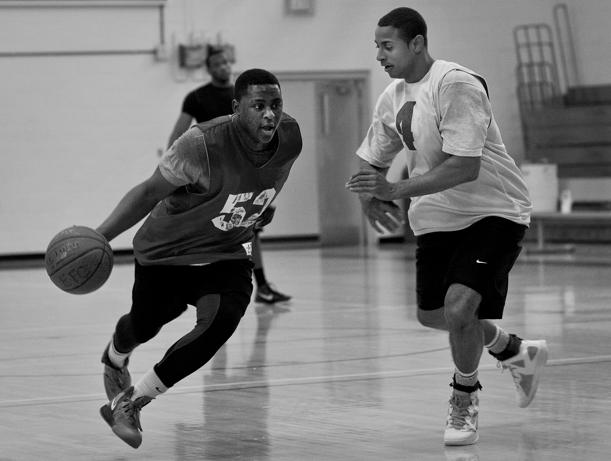 A player dribbles past a defender during a 3-on-3 basketball tournament held Jan. 24 at the Eglin Air Force Base, Fla., gym.  A total of six teams battled it out in 10-minute games in the double elimination tournament.  (U.S. Air Force photo/Samuel King Jr.)