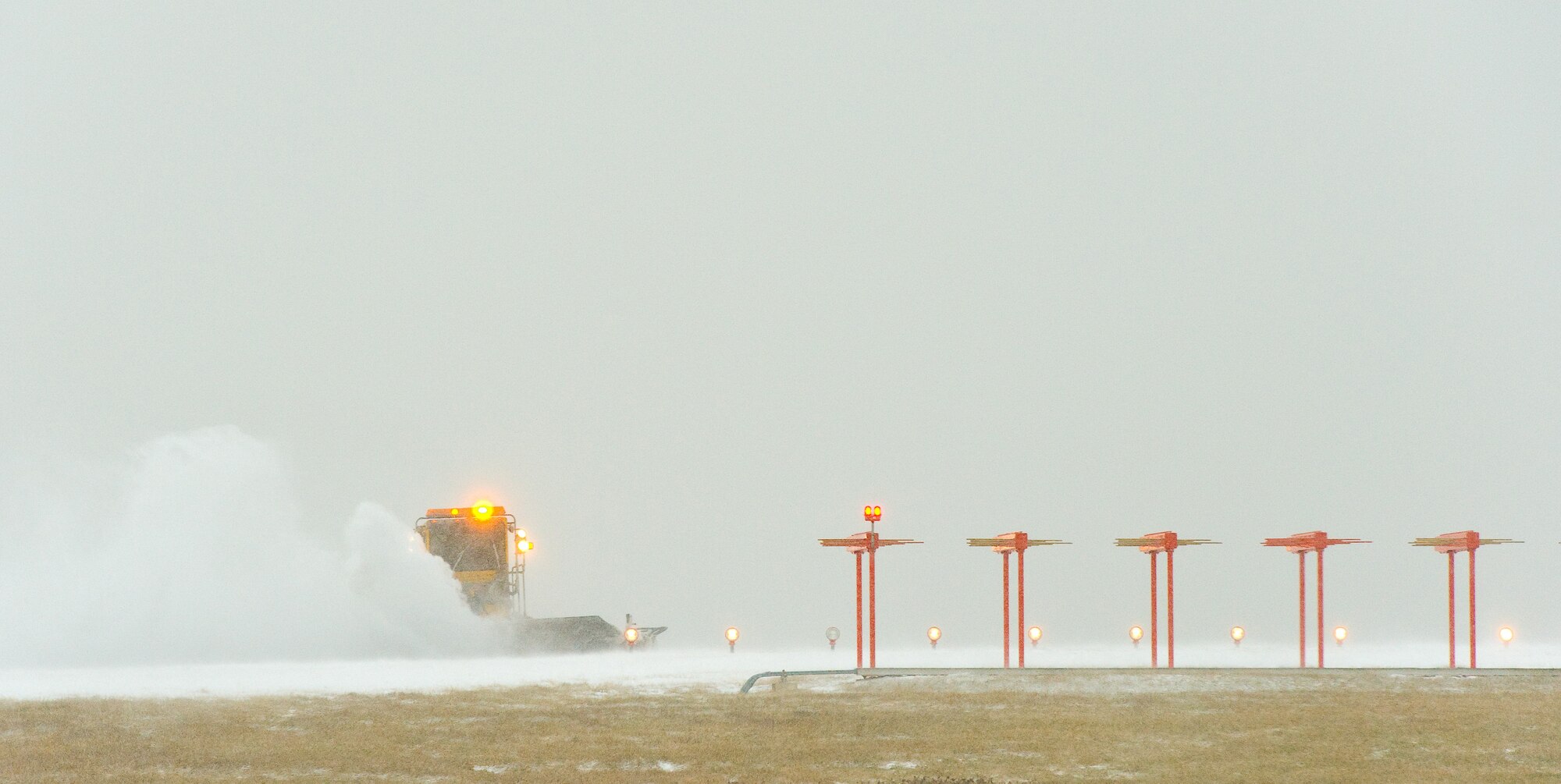 A snow plow from the 436th Civil Engineer Squadron clears snow from the runway Jan. 21, 2014, at Dover Air Force Base, Del. As the wind-driven snow fell and even after, the base continued normal operations as Team Dover personnel initiated snow removal throughout the base. (U.S. Air Force photo/Roland Balik)