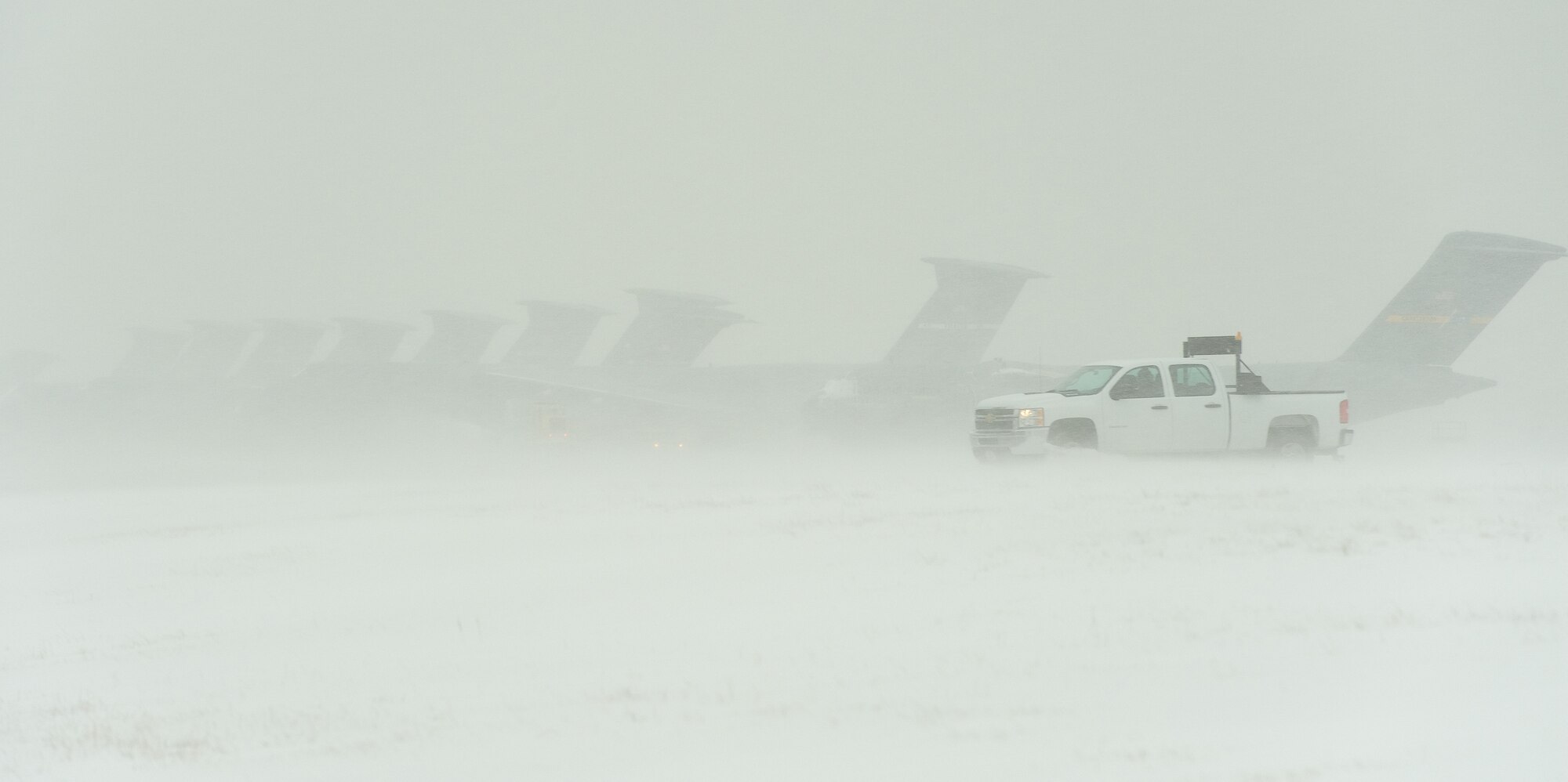 A follow-me vehicle from 436th Aircraft Maintenance Squadron Transient Maintenance section drives down the flight line Jan. 21, 2014, at Dover Air Force Base, Del. The base continued normal operations as Team Dover personnel prepared for the second major snow storm to hit the area. (U.S. Air Force photo/Roland Balik)