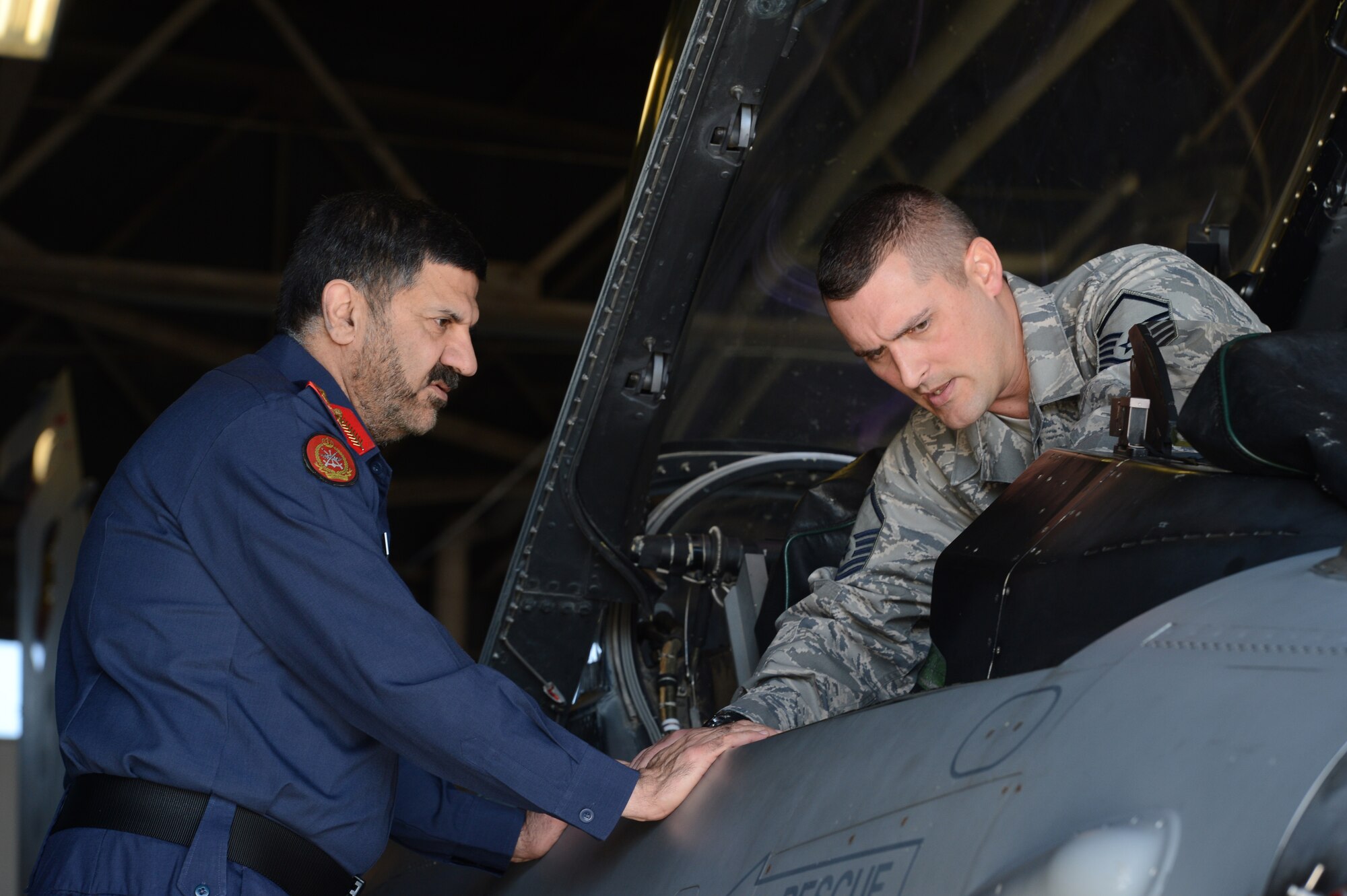 Staff Brig. Gen. Abd-al-Aziz Husn Al-Reyes, Kuwait Ministry of Defense director of moral guidance and public relations (left), observes as U.S. Air Force Master Sgt. Neil Stokley, 20th Maintenance Group aircraft armament specialist, details the inside of an F-16 Fighting Falcon cockpit, Shaw Air Force Base, S.C., Jan 21. 2014. Al-Reyes and three of his officers toured Shaw AFB and met Airmen who are critical to the success of Shaw’s mission. (U.S. Air Force photo by Airman 1st Class Jonathan Bass/Released)