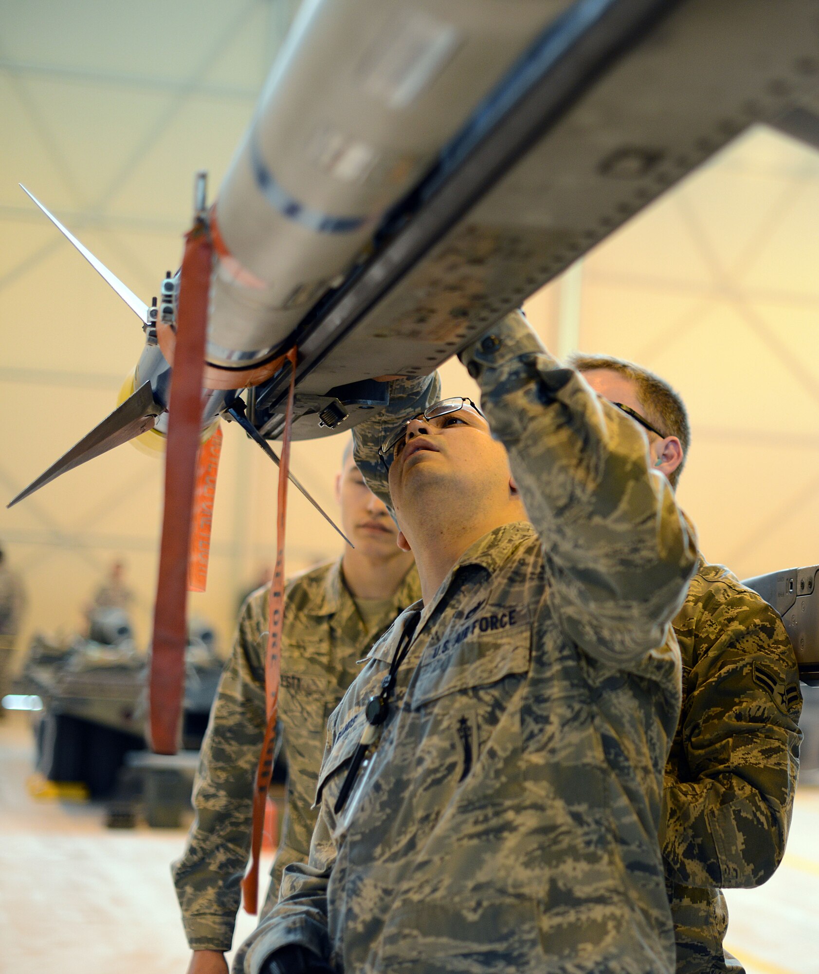Staff Sgt. Brandon Ramos, 31st Aircraft Maintenance Squadron weapons load crew chief, inspects a weapon loaded onto an F-16 Fighting Falcon during an annual weapons load crew competition Jan. 23, 2014, at Aviano Air Base, Italy. Load crew competitions ensure Airmen maintain their skills while also promoting competition and camaraderie among the squadrons.(U.S. Air Force photo/Airman 1st Class Deana Heitzman)      