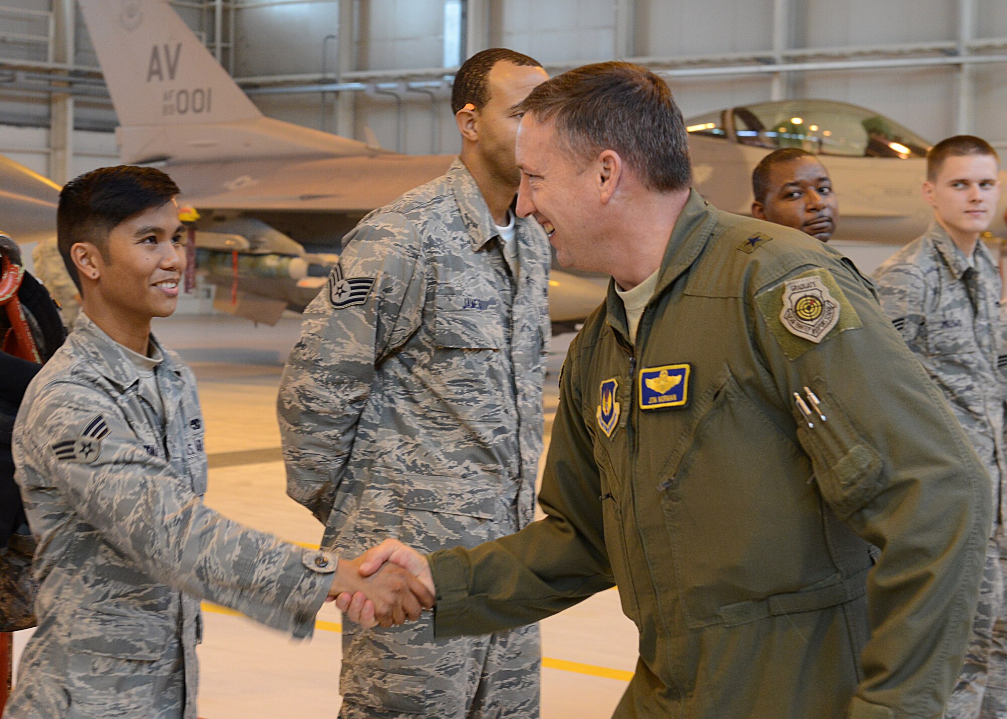 Brig. Gen. Jon A. Norman, 31st Fighter Wing commander, shakes hands with Senior Airman Bryan Ednave, 31st Aircraft Maintenance Squadron weapons load crew member, after the annual weapons load crew competition, Jan. 23, 2014, at Aviano Air Base, Italy. The winner will be announced during the Maintenance Professional of the Year Banquet. (U.S. Air Force photo/Airman 1st Class Ryan Conroy) 