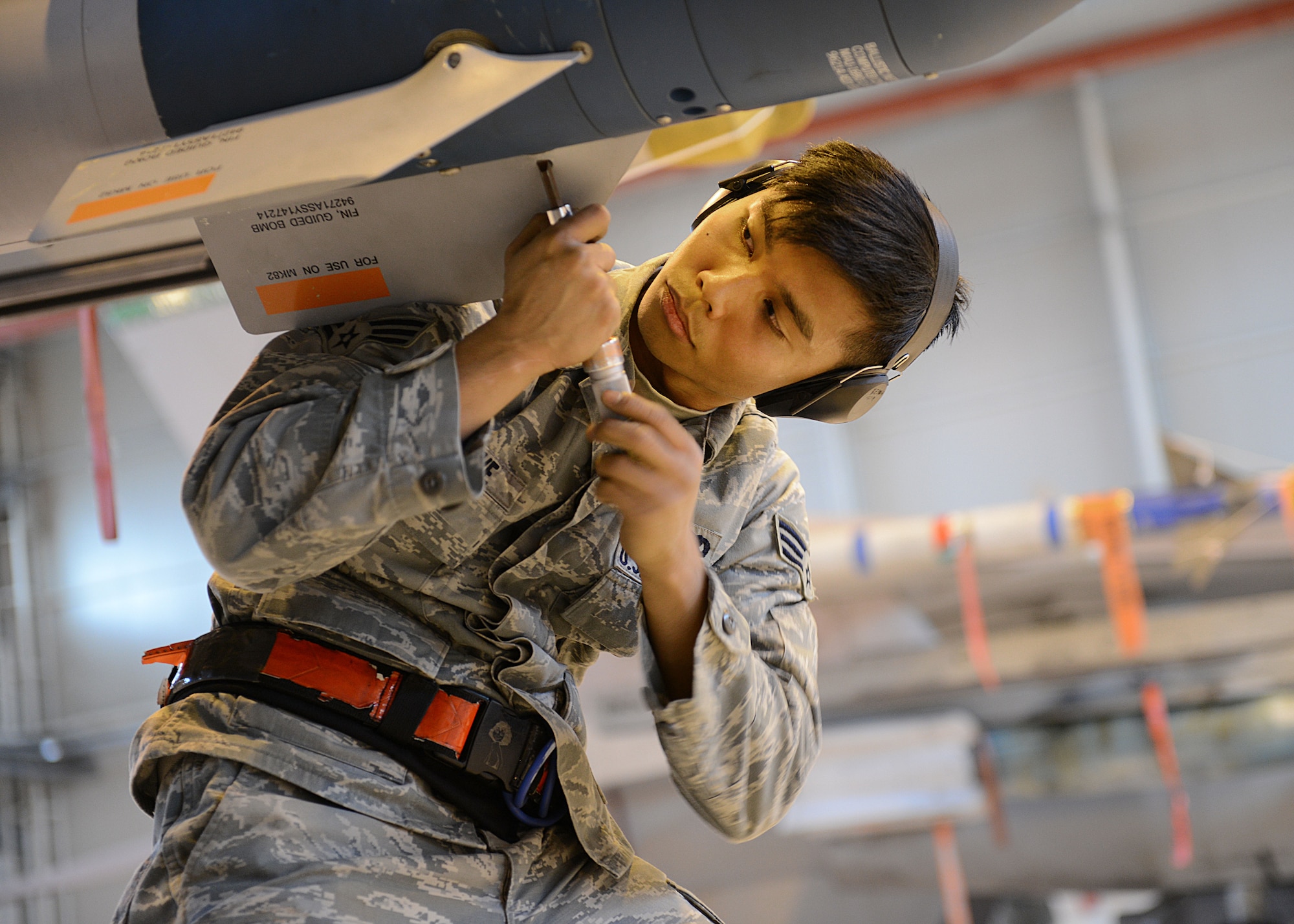 Senior Airman Bryan Ednave, 31st Aircraft Maintenance Squadron weapons load crew member, adjusts the fins on munition during an annual weapons load crew competition, Jan. 23, 2014, at Aviano Air Base, Italy. Load crew competitions are held four times a year in addition to an annual competition to determine the best load crew of the year.  (U.S. Air Force photo/Airman 1st Class Ryan Conroy) 