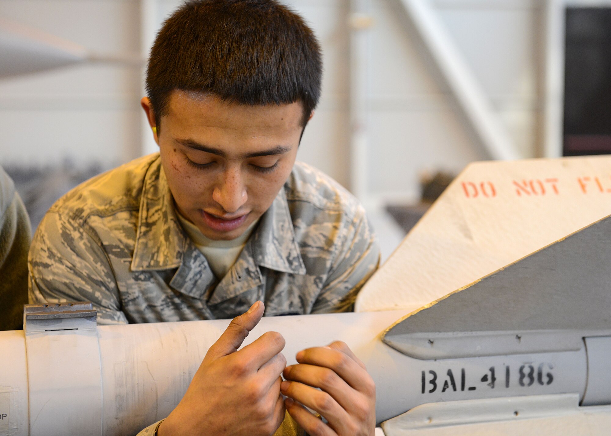 Senior Airman Christian Fernandez, 31st Aircraft Maintenance Squadron weapons load crew member, carries a munition during the annual weapons load competition, Jan. 23, 2014, at Aviano Air Base, Italy. Load crew competitions ensure Airmen maintain their skills while also promoting competition and camaraderie among the squadrons. (U.S. Air Force photo/Airman 1st Class Ryan Conroy) 