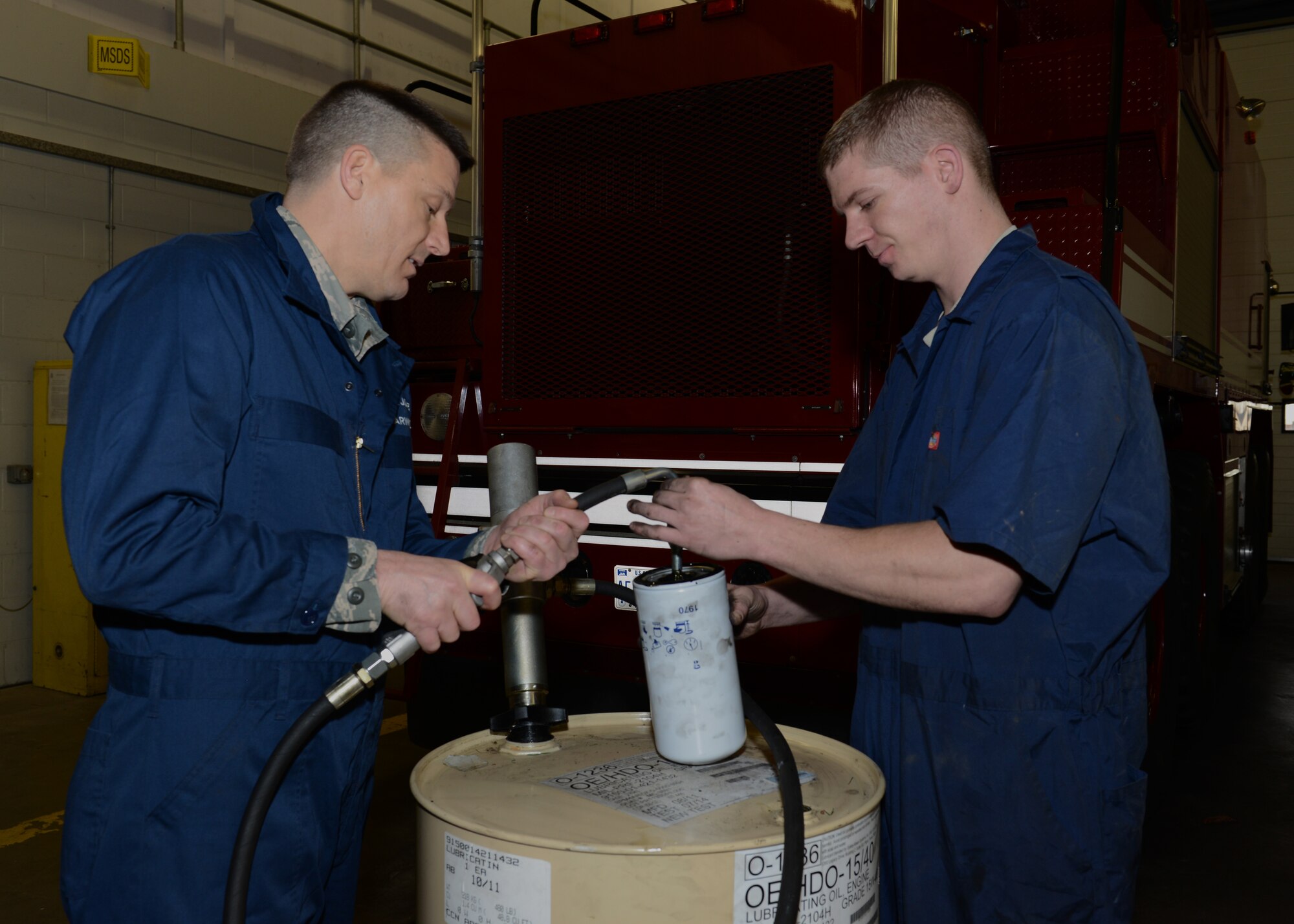 U.S. Air Force Senior Airman Jason Brown, right, 100th Logistics Readiness Squadron vehicle maintenance journeyman from Akron, Ohio, and U.S. Air Force Chief Master Sgt. Tracy Jones, 100th Air Refueling Wing command chief, fill an oil filter with oil prior to installing it on a fire truck Jan. 23, 2014, on RAF Mildenhall, England. Brown showed Jones some basic maintenance techniques as part of the “Dirty Jobs” program. The “Dirty Jobs” program affords Airmen the opportunity to show base leadership first-hand what their jobs entail. (U.S. Air Force photo by Airman 1st Class Preston Webb/Released)