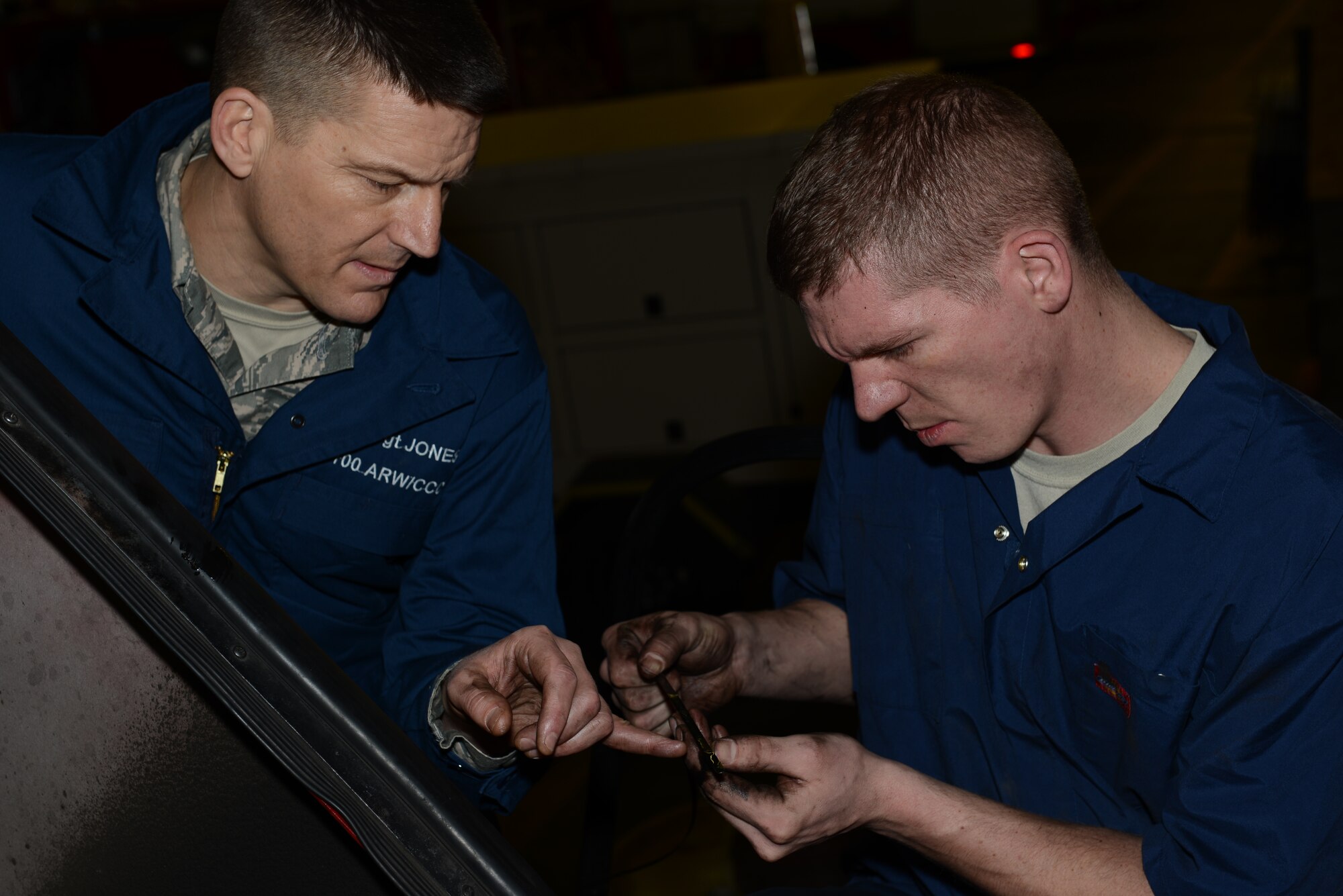 U.S. Air Force Senior Airman Jason Brown, right, 100th Logistics Readiness Squadron vehicle maintenance journeyman from Akron, Ohio, and U.S. Air Force Chief Master Sgt. Tracy Jones, 100th Air Refueling Wing command chief, check a fire truck’s dipstick Jan. 23, 2014, on RAF Mildenhall, England. Brown and Jones repeatedly checked the oil level in the fire truck to ensure it wasn’t over-filled. Brown showed Jones how to perform routine maintenance as part of the “Dirty Jobs” program. (U.S. Air Force photo by Airman 1st Class Preston Webb/Released)