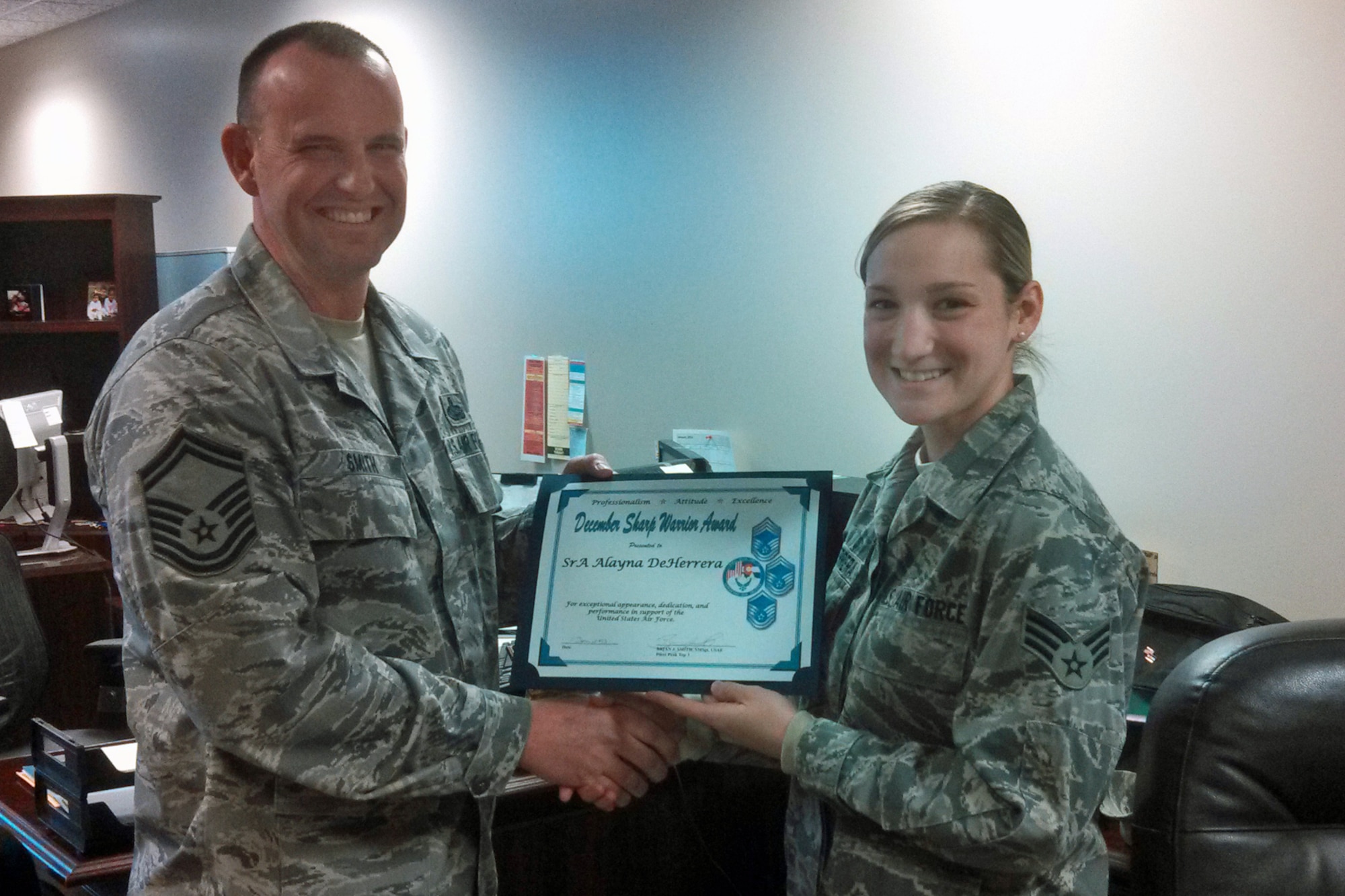 PETERSON AIR FORCE BASE, Colo. – Senior Master Sgt. Brian Smith (left), a representative of the Pikes Peak Top 3, presents the December 2013 Sharp Warrior Award to Senior Airman Alayna Deherrera from the 21st Mission Support Group staff. Deherrera provides excellent customer service and displays impeccable professionalism as the MSG workflow manager, a position normally held by an NCO. She is the driving force behind the 21 MSG's 100 percent on-time-rate for all taskers sent to the 21st Space Wing, 14th Air Force and Air Force Space Command. Deherrera not only keeps the MSG front office on track to meet all deadlines, but also tracks suspenses for six squadrons and one detachment. She expertly coordinates hundreds of officer performance reports, enlisted performance reports, decorations and promotion recommendation forms, ensuring that members’ records accurately portray the hard work they contribute. She does this with the utmost professionalism and customer service without missing a beat. (U.S. Air Force photo)