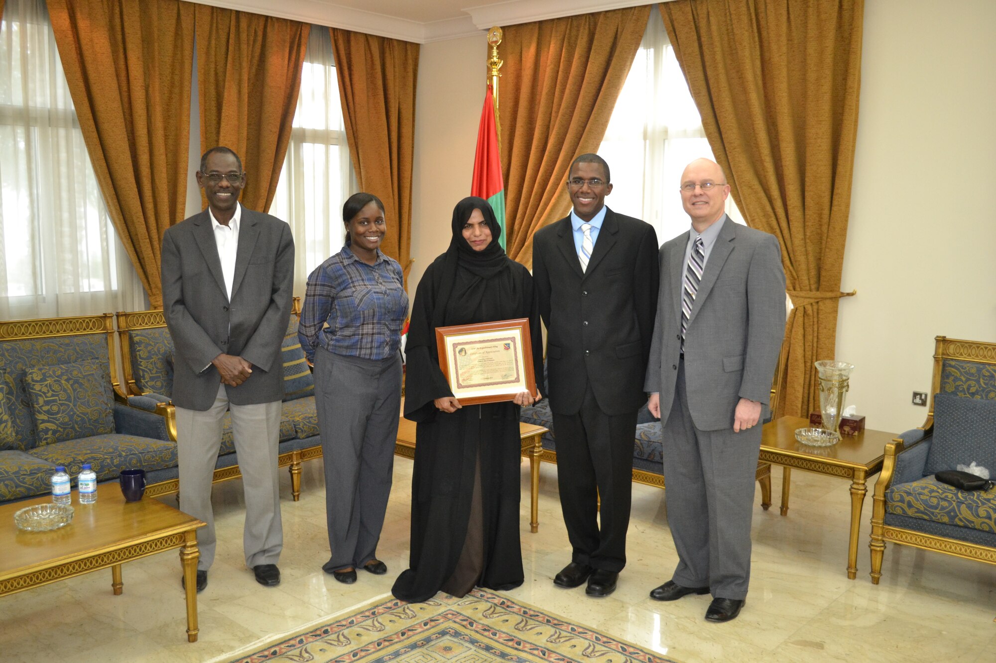 Members of the Host Nation Coordination Cell at Al Udeid Air Base, Qatar, present a certificate of appreciation to Fatema A. Allah Al-Mutawea of the United Arab Emirates consular section at the UAE Embassy in Doha, Jan. 26, 2014.  Al-Mutawea provides support above and beyond to the HNCC in processing visas for U.S. forces traveling to UAE.  Because of the strong working relationship between the 379th Air Expeditionary Wing HNCC and the UAE Embassy’s consular section, Al-Mutawea mitigated a three week backlog of UAE visa processing in the United States. (U.S. Air Force Photo by Maj. Nicole David)