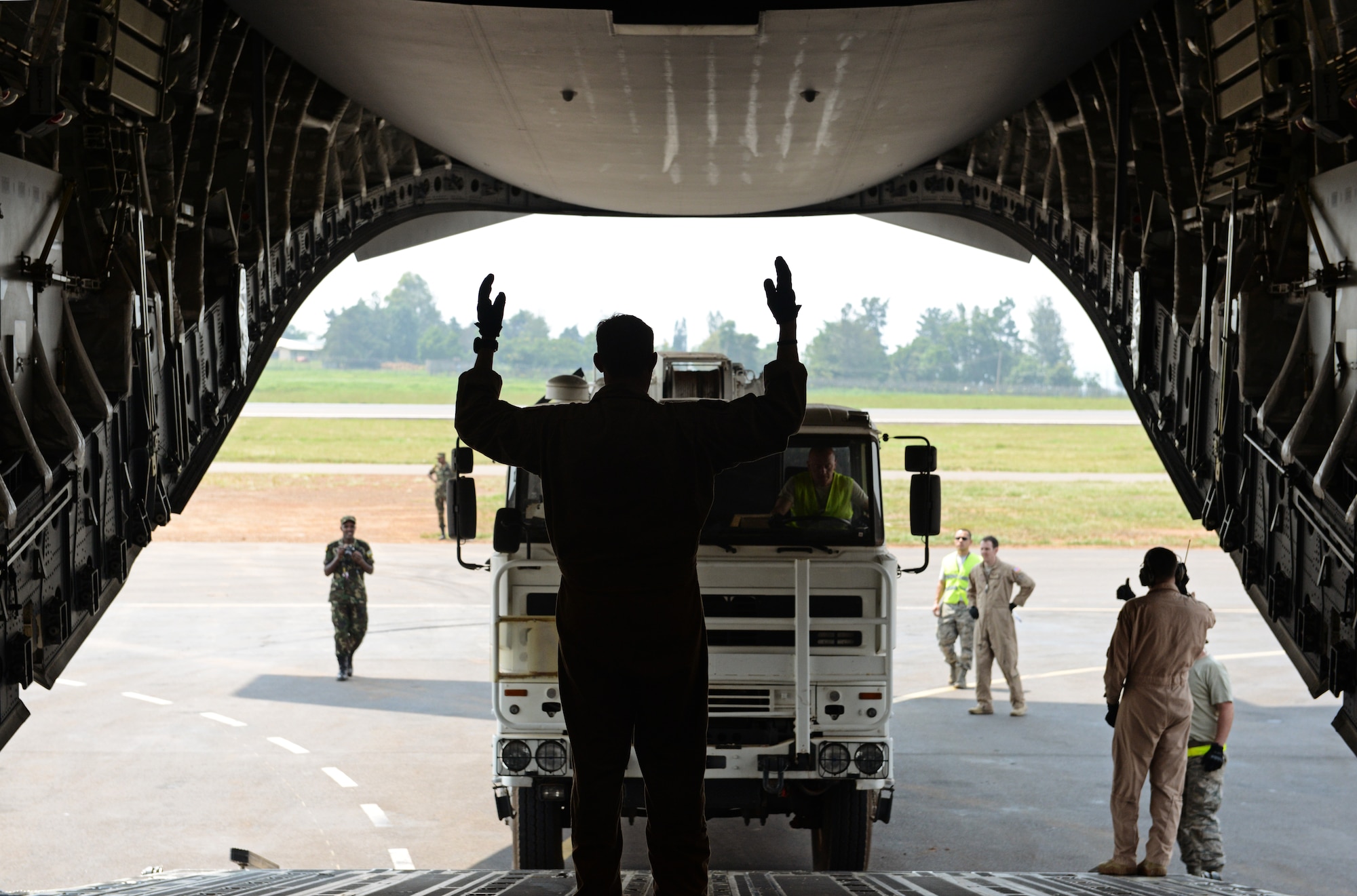 Airmen from the 435th Air Ground Operations Wing, 62nd Airlift Wing, and the 571st Contingency Response Group load vehicles, equipment and Rwandan soldiers onto a C-17 Globemaster III in Rwanda, Africa Jan. 19, 2014. U.S. forces will transport a total number of 850 Rwandan soldiers and more than 1000 tons of equipment into the Central African Republic to aid French and African Union operations against militants during this three week-long operation. (U.S. Air Force photo/ Staff Sgt. Ryan Crane)