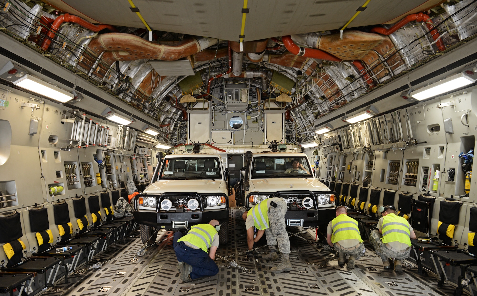Airmen from the 435th Air Ground Operations Wing, 62nd Airlift Wing, and the 571st Contingency Response Group load vehicles, equipment and Rwandan soldiers onto a C-17 Globemaster III in Rwanda, Africa Jan. 19, 2014. U.S. forces will transport a total number of 850 Rwandan soldiers and more than 1000 tons of equipment into the Central African Republic to aid French and African Union operations against militants during this three week-long operation. (U.S. Air Force photo/ Staff Sgt. Ryan Crane)