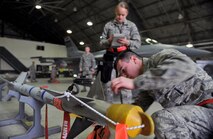 Senior Airman Robert Judelsohn, 36th Aircraft Maintenance Unit weapons loader, inspects a bomb prior to placing it onto an F-16 Fighting Falcon during a quarterly weapons load crew competition at Osan Air Base, Republic of Korea, Jan. 24, 2014. In order for the load crews to earn their place in the competition, they must prove themselves during their monthly proficiency loads, quarterly evaluations, and every-day mission. (U.S. Air Force photo/Senior Airman Siuta B. Ika)