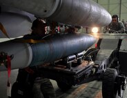 Staff Sgt. Devin Harris, 36th Aircraft Maintenance Unit weapons loader, guides a bomb onto an F-16 Fighting Falcon during a quarterly weapons load crew competition at Osan Air Base, Republic of Korea, Jan. 24, 2014. During a weapons load crew competition, each member has a set of tasks to carry out and must work on a team of three or four, depending on the aircraft they are responsible for. (U.S. Air Force photo/Senior Airman Siuta B. Ika)