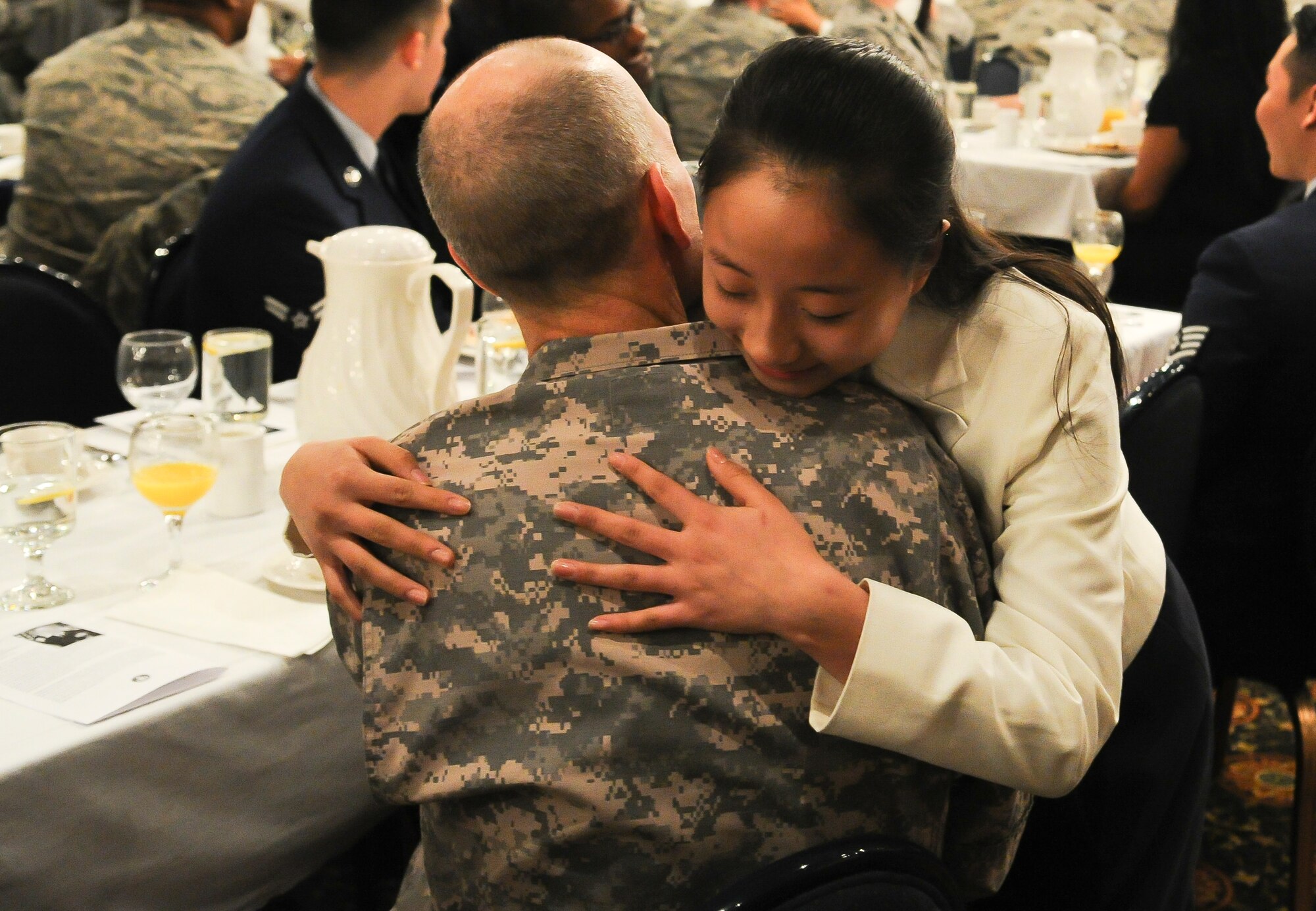 A member of the Far East Broadcasting Company's Children's Choir hugs a soldier in the audience at the National Prayer Breakfast Jan. 23, 2014, at Osan Air Base, Republic of Korea. The breakfast featured several performances and scripture readings from different religions. (U.S. Air Force photo by Staff Sgt. Jake Barreiro)