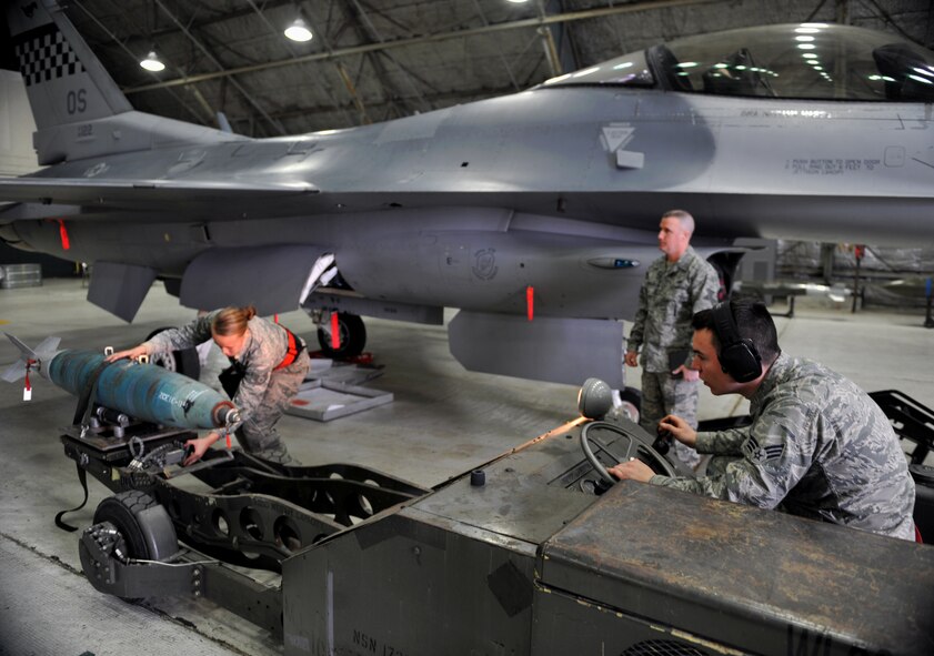Senior Airman Robert Judelsohn watches Staff Sgt. Devin Harris prep a bomb to be placed onto an F-16 Fighting Falcon during a quarterly weapons load crew competition at Osan Air Base, Republic of Korea, Jan. 24, 2014. Harris and Judelsohn are both weapons loaders with the 36th Aircraft Maintenance Unit. (U.S. Air Force photo/Senior Airman Siuta B. Ika)