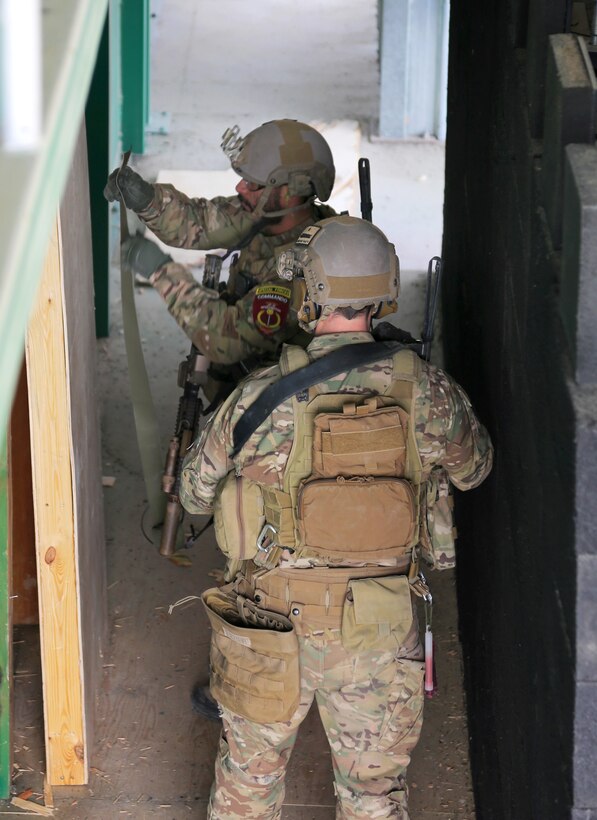 U.S. Special Forces soldiers set an explosive charge on a door to simulate a breach during a close-quarters battle drill near Camp Commando in Kabul province, Afghanistan, Jan. 23, 2014.
