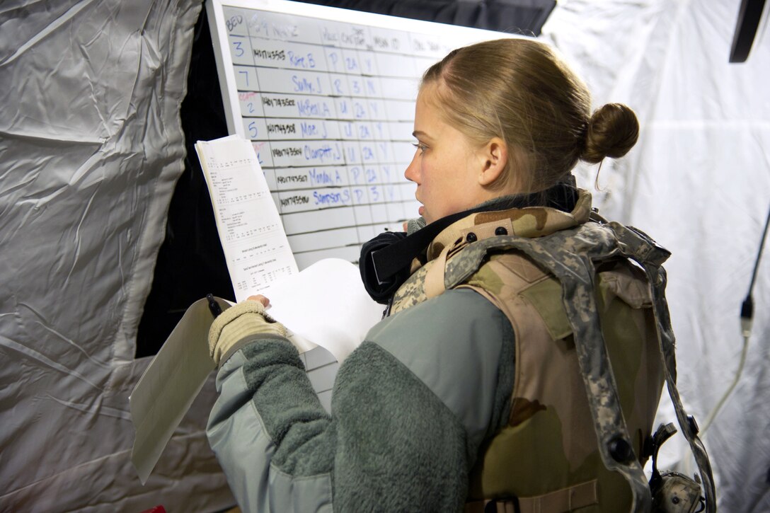 Air Force Staff Sgt. Kristen Thompson updates a mission board inside of the en-route patient staging systems tent during a field exercise at the Joint Readiness Training Center on Fort Polk, La., Jan. 17, 2014. Thompson, a health service management craftsman, is assigned to the 375th Medical Group, Scott Air Force Base, Ill.