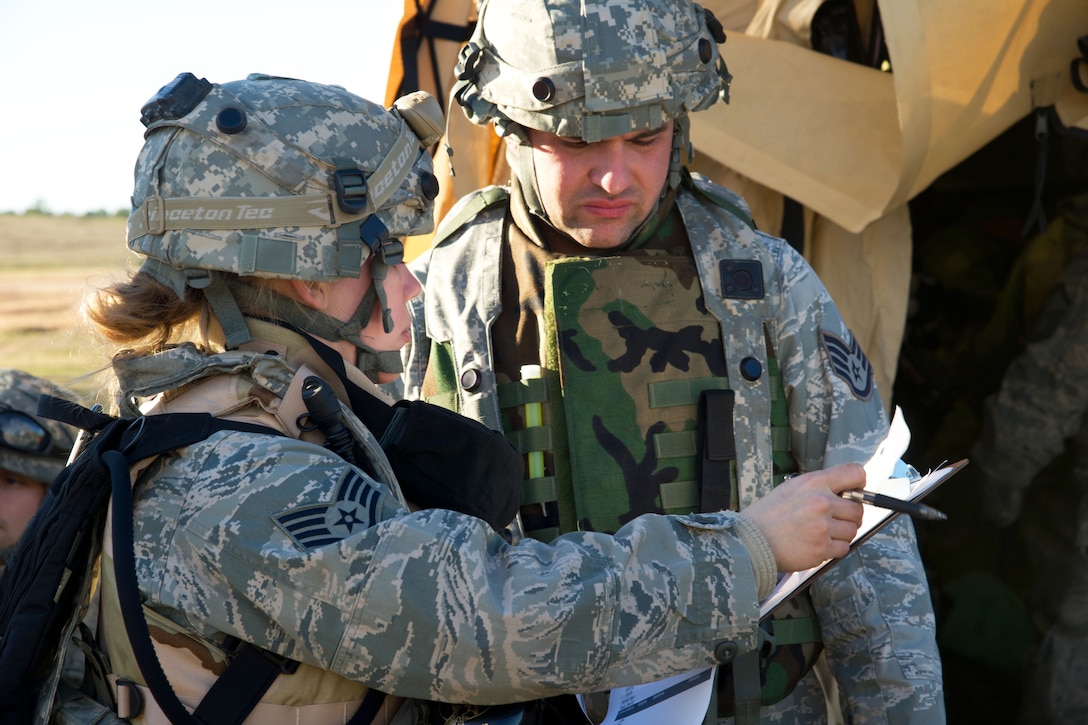 U.S. Air Force Staff Sgts. Kristen Thompson, left, and Zachary Parker go over situation reports during a field exercise at the Joint Readiness Training Center on Fort Polk, La., Jan. 17, 2014. Thompson, a health service management craftsman, is assigned to the 375th Medical Group, Scott Air Force Base, Ill., and Parker, a radio frequency transmission specialist, is assigned to the 43rd Aeromedical Evacuation Squadron, Pope Army Air Field N.C.
