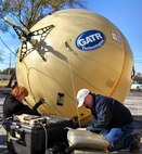 James Mayers (right), lead satellite communications engineer, and Martha Lively, satellite communications logistician, both in Marine Air-Ground Task Force Command, Control and Communications at Marine Corps Systems Command, set up the an inflatable satellite communications antenna Nov. 18 in Huntsville, Ala. Mayers was selected by the Armed Forces Communications and Electronics Association and U.S. Naval Institute to receive the 2014 Copernicus Award for his contributions to the satellite communications field in 2013. 
