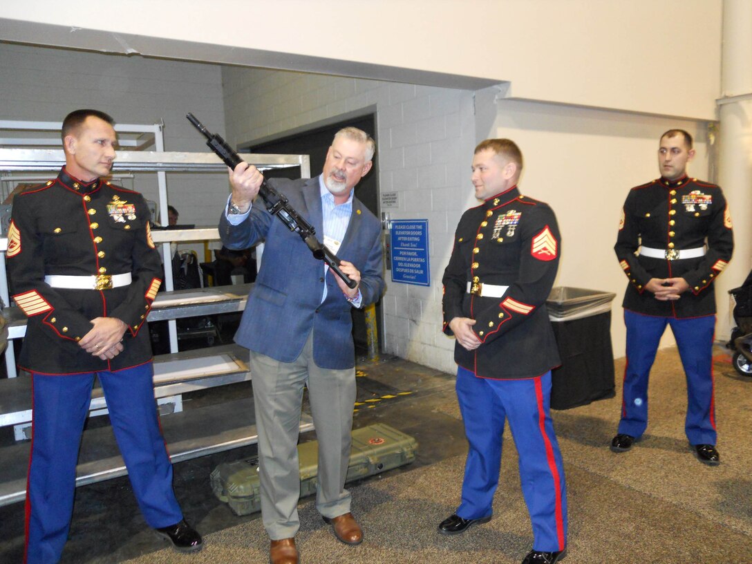 Jason Mann, president of the Marine Corps Scout Sniper Association, presents a LARUE PredatOBR 7.62 rifle to Sgt. David Mortensen on Jan. 14, 2014. Mortensen was the first to receive the Marine Corps Scout Sniper Instructor of the Year Award. 