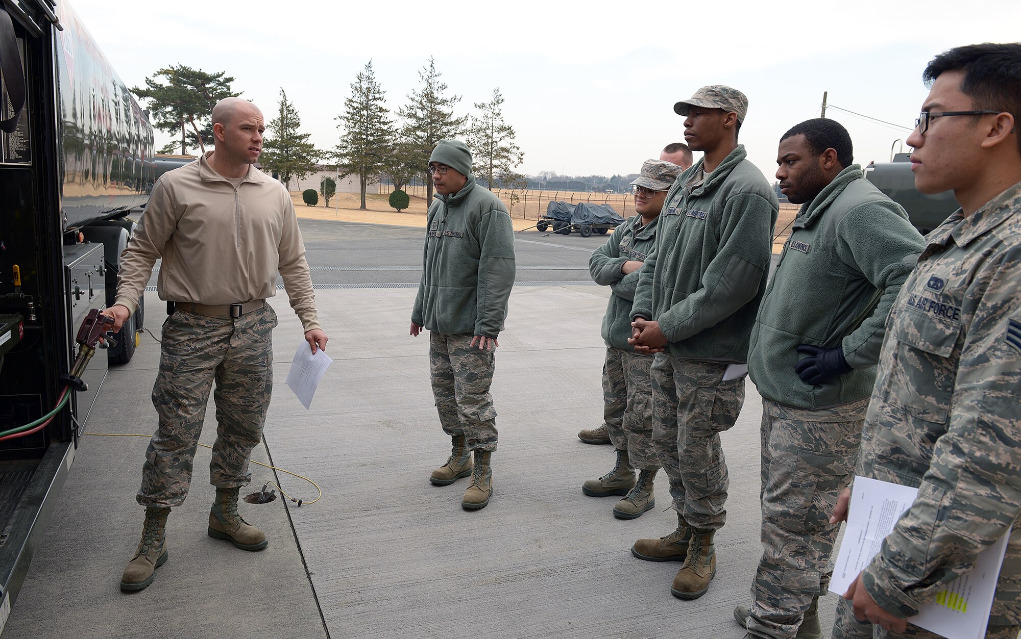 Staff Sgt. Joshua Acosta, 374th Logistics Readiness Squadron non-commissioned officer in charge of refueling maintenance, instructs Airmen on safety procedures for the R-11 refueling truck at Yokota Air Base, Japan, Jan. 24, 2014. R-11 fuel tanks hold a maximum capacity of 6,000 gallons and are able to issue fuel at a rate of 600 gallons per minute. (U.S. Air Force photo by Airman 1st Class David Danford/Released)