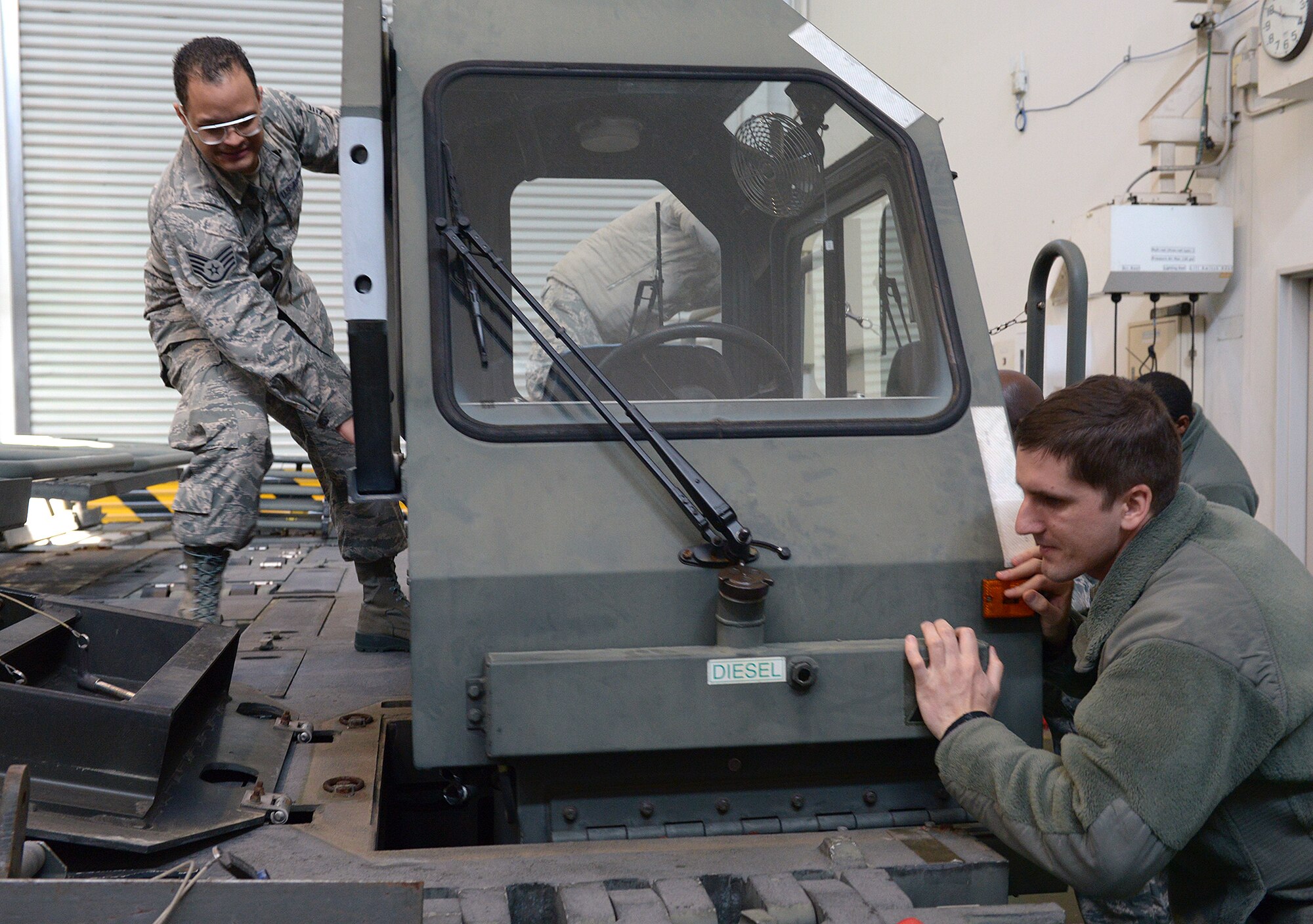 Staff Sgts. Angel Suarez, 374th Logistics Readiness Squadron non-commissioned officer in charge (left), and David Klimas, 374th Logistics Readiness Squadron flight support manger (right), move the cab of a Halverson 25K loader at Yokota Air Base, Japan, Jan. 24, 2014. Members of the 374th Logistics Readiness Squadron reconfigured the loading vehicle as part of a day-long training exercise. (U.S. Air Force photo by Airman 1st Class David Danford/Released)