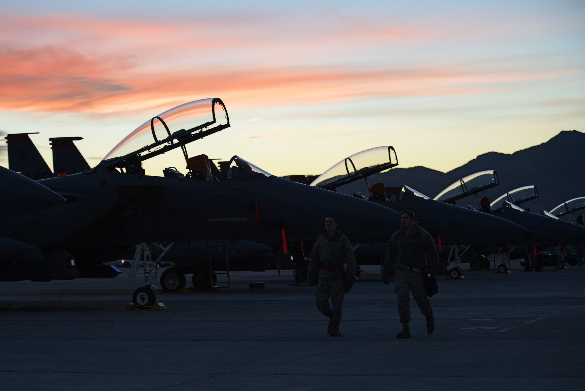 Senior Airman Cameron Delsol, 366th Aircraft Maintenance Squadron lead crew three man and Staff Sgt. Douglas Brown, 366th AMXS lead crew team chief, walk along the flight line at Nellis Air Force Base, Nev., Jan. 28, 2014. The Airmen are more than 3,200 personnel participating in Red Flag 14-1. The premier exercise gives them the opportunity to experience realistic, stressful combat situations in a controlled environment to increase their ability to complete missions and return home. (U.S. Air Force photo by Senior Airman Benjamin Sutton/Released) 