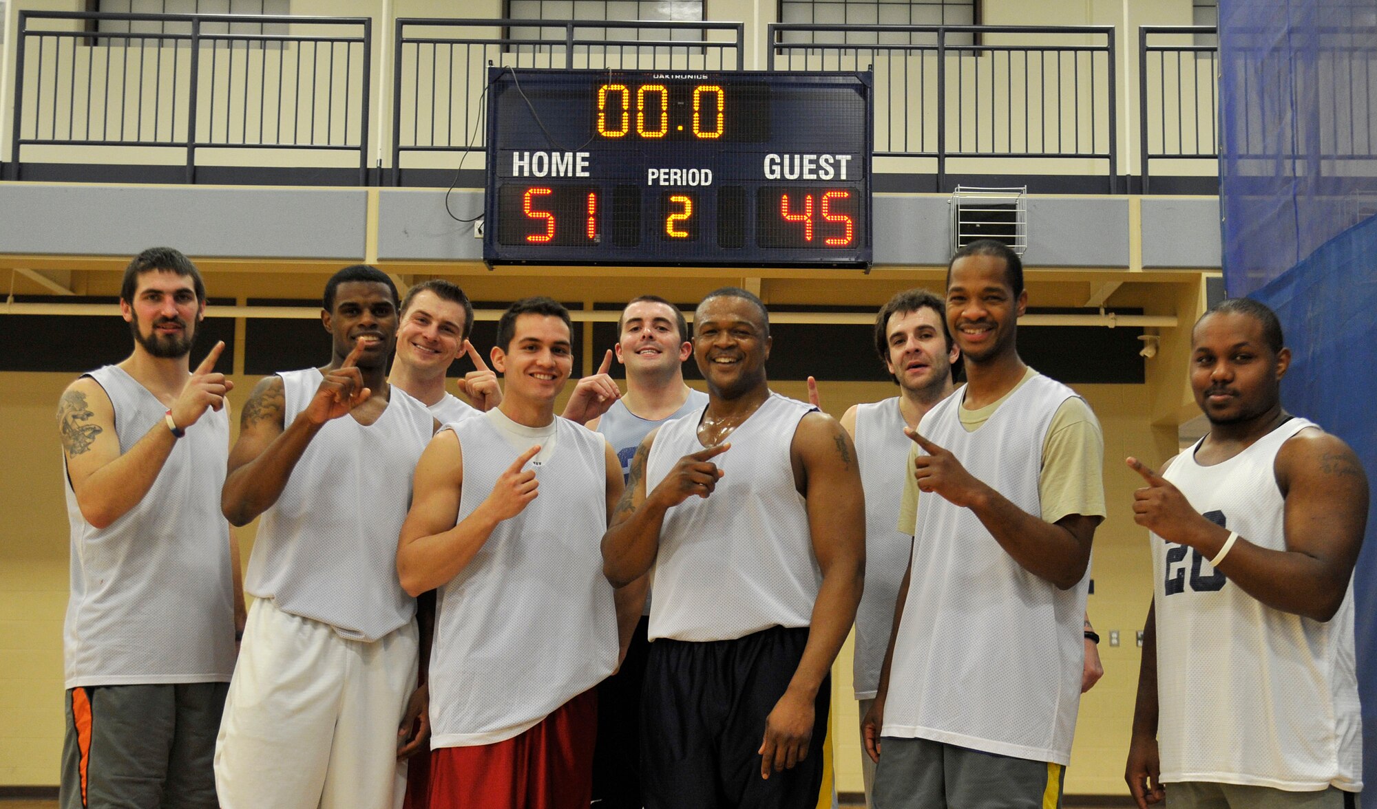 Members from the 92nd Force Support Squadron’s intramural basketball team pose for a photo in front of the scoreboard in the fitness center at Fairchild Air Force Base, Wash., Jan. 23, 2014. The 92nd FSS team won the championship game with a final score of 51 to 45. (U.S. Air Force photo by Airman 1st Class Ryan Zeski/Released)
