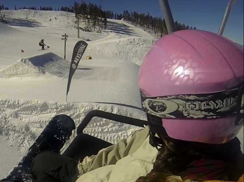 140125-F-GP871-005 Sarah Goldman-Foster watches a skier take flight off ramps on a slope of Keystone Resort, Colo. Jan. 25, as she rides the ski lift to the top of the resort. (U.S. Air Force photo by Tech. Sgt. Stacy Foster)