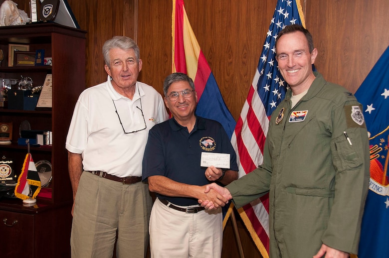 David Ray, left, Quail Creek Veterans Golf Association charitable research committee chairman, Tom Contreras, Quail Creek Veterans Golf Association president, present Col. Phil Purcell, Commander of the 162nd Fighter Wing with $1,000 check for Family Readiness Office.