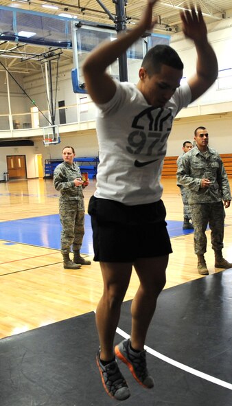 U.S. Air Force Senior Airman Joshua Massas-Borges, 7th Equipment Maintenance Squadron, jumps while performing a burpee Jan. 24, 2014, at Dyess Air Force Base, Texas. The Dyess Fitness Center hosted the first Warrior Challenge of the year, which consisted of seven different exercises in a timed circuit. (U.S. Air Force photo by Senior Airman Shannon Hall/Released)