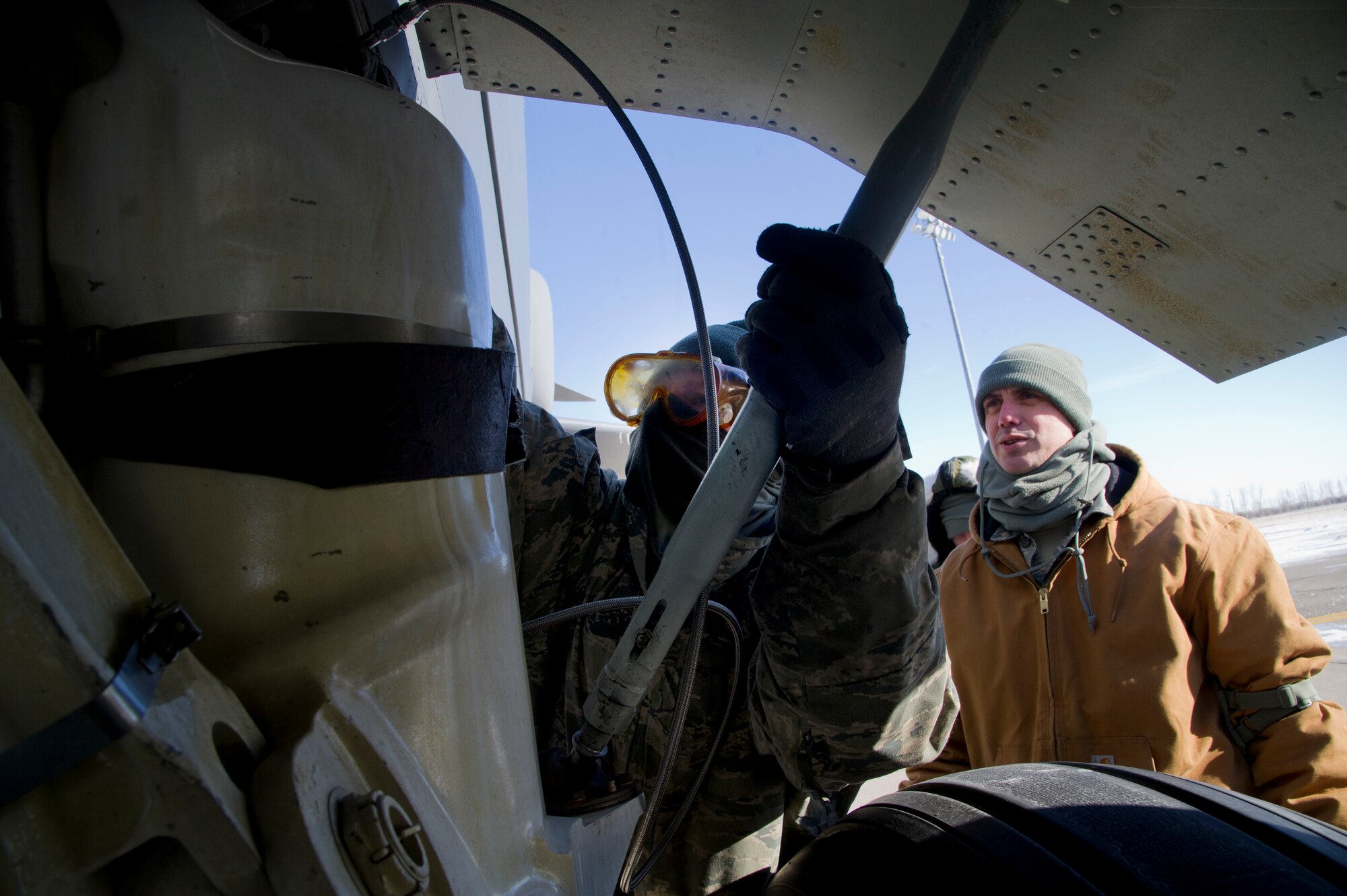 A crew chief from the 5th Aircraft Maintenance Squadron performs strut serving on a B-52H Stratofortress during a one-on-one training session with Tech. Sgt. Christopher McCauley, 372nd Training Squadron Detachment 22 crew chief instructor at Minot Air Force Base, N.D., Jan. 23, 2013. Det. 22 is part of Air Education and Training Command and is assigned here as a tenant unit providing on-site formal technical instruction on many B-52H maintenance skills ranging from hydraulic maintenance to engine operation. (U.S. Air Force photo/Senior Airman Brittany Y. Auld)