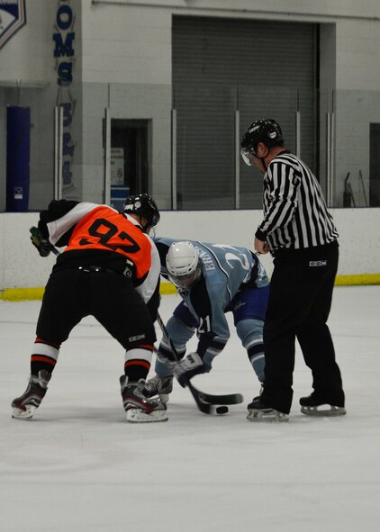 Sam Ernst, Dover Eagles center, right, faces off with a Fraternal Order of Police forward during a charity hockey game Jan. 26, 2014, at Centre Ice Rink in Harrington, Del. The Eagles and the FOP finished in a 9-9 tie. (U.S. Air Force photo/Airman 1st Class William Johnson)