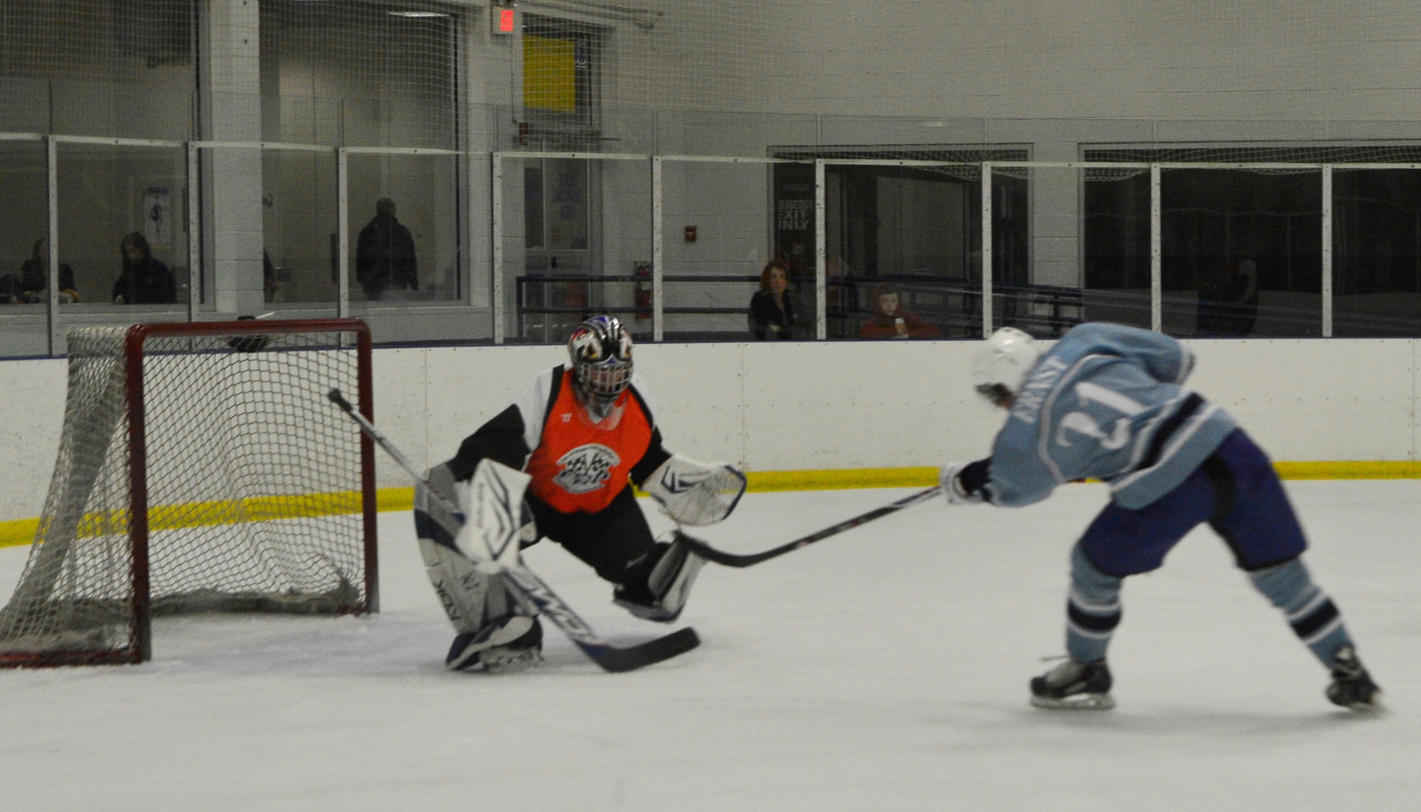 Sam Ernst, Dover Eagles center shoots for a goal but is blocked by Matthew McKenzie, Fraternal Order of Police goalie, during a charity game Jan. 27, 2014, at the Centre Ice Rink in Harrington, Del. Ernest later got two goals on McKenzie to contribute to the 9-9 tie game between the two teams. (U.S. Air Force photo/Airman 1st Class William Johnson)