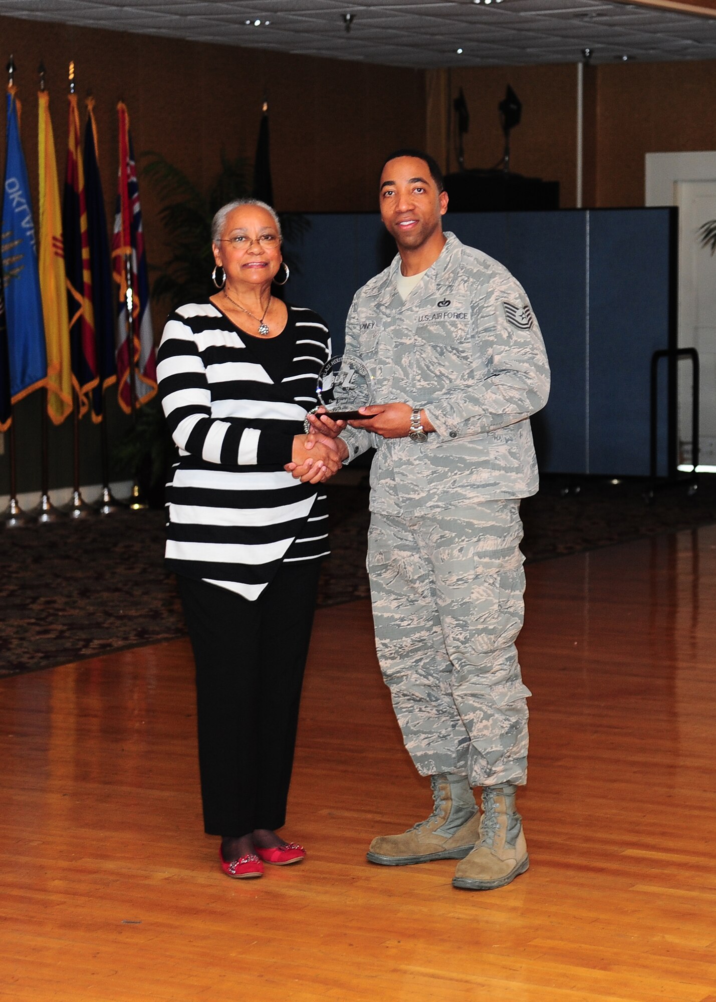 Mrs. Vivian Irby, daughter-in-law of George Irby, is awarded a Team BLAZE token of appreciation by Tech. Sgt. Horace Conney, 14th Civil Engineer Squadron, for being the guest speaker and for her continuous community support at the Martin Luther King, Jr. luncheon Jan. 24 at the Columbus Club.