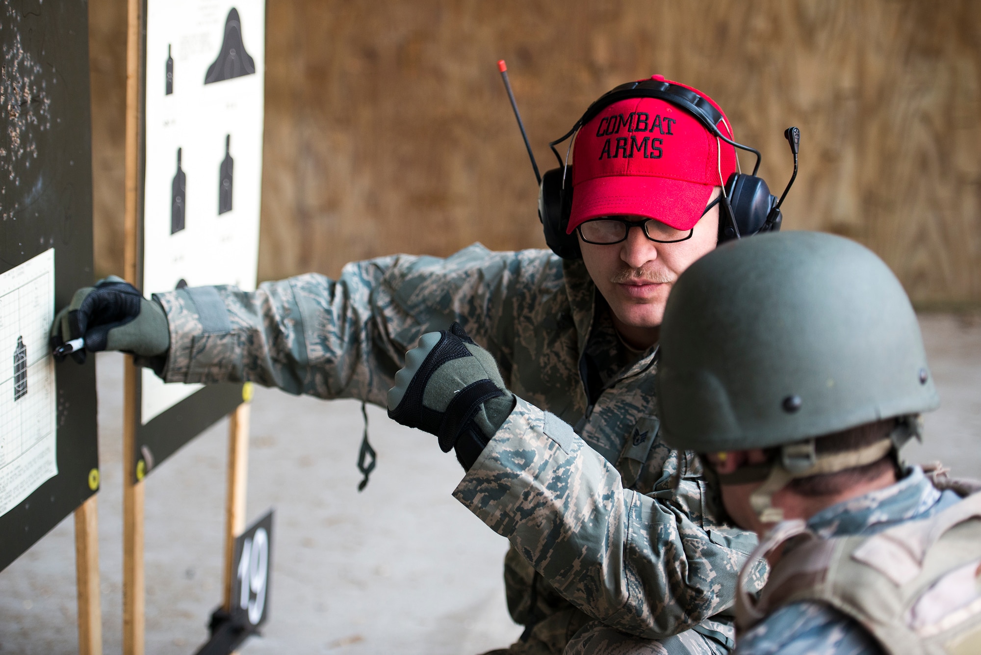 U.S. Air Force Staff Sgt. Shane Lafever, 823d Base Defense Squadron combat arms training and maintenance (CATM) instructor, marks shots on a target at Moody Air Force Base, Ga., Jan. 28, 2014. Prior to qualification shooting, CATM instructors help Airmen fine-tune their scopes after several rounds of fire. (U.S. Air Force photo by Airman 1st Class Ryan Callaghan/Released)
