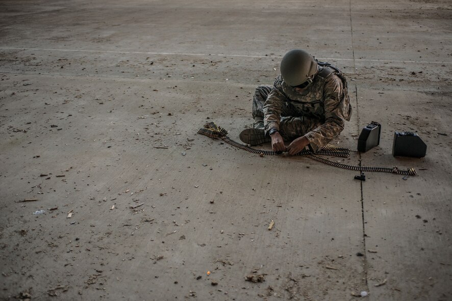U.S. Air Force Airman 1st Class James Harris, 23d Security Forces Squadron team member, breaks apart ammo links at Moody Air Force Base, Ga., Jan. 22, 2014. Airmen attempting to qualify on the M249 light machine gun shot a series of three-second bursts, firing a total of 570 rounds at the target. (U.S. Air Force photo by Airman 1st Class Ryan Callaghan/Released)
