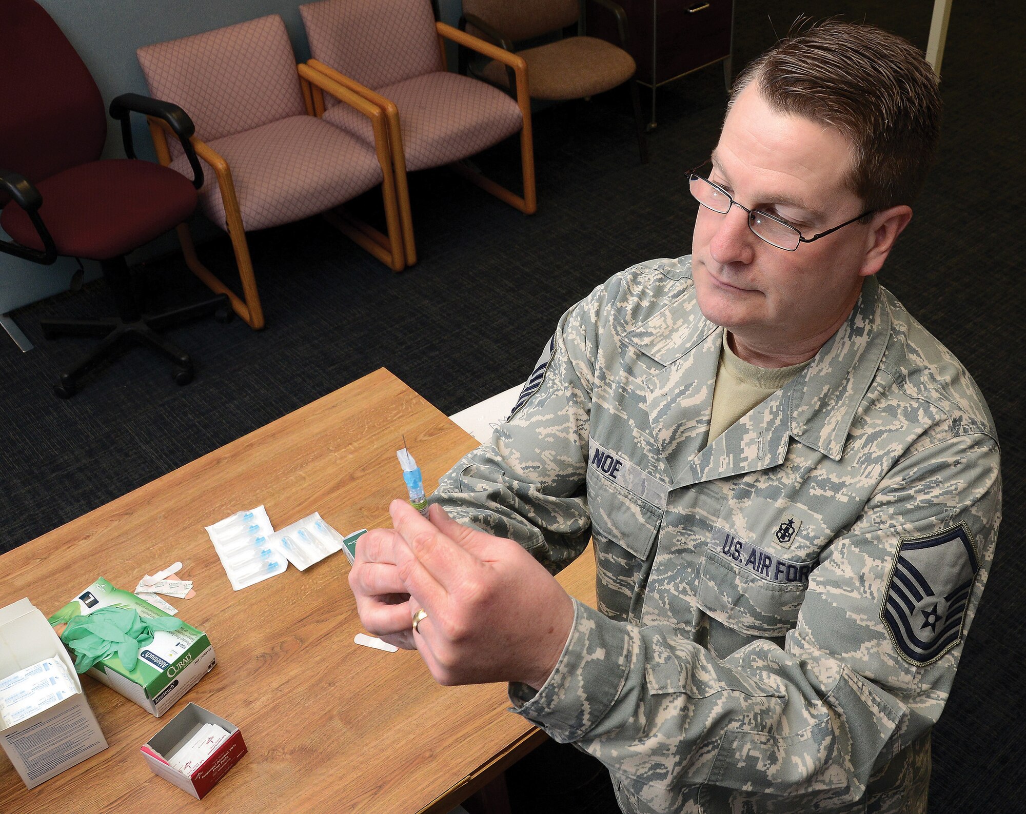 WRIGHT-PATTERSON AIR FORCE BASE, Ohio – Master Sgt. Todd Noe, 445th Aerospace Medicine Squadron, NCO in charge of immunizations, prepares a syringe before administering one of the last flu shots for the 2013-14 season during the Jan. 11, 2014 unit training assembly. More than 1,850 shots were given by the 445 AMDS medical staff in the last two months. (U.S. Air Force photo/Tech. Sgt. Frank Oliver)