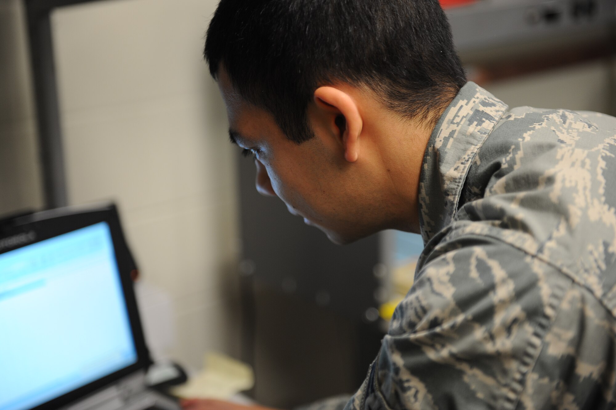 Airman 1st Class Ivan Najera, a client systems technician with the Minot Air Force Base 5th Communications Squadron, works on reprogramming a computer at the 5th CS building. Najera is part of a team of Airmen responsible for maintain and supporting equipment essential to the mission’s communication through computers and radios. (U.S. Air Force photo/Airman 1st Class Lauren Pitts) 