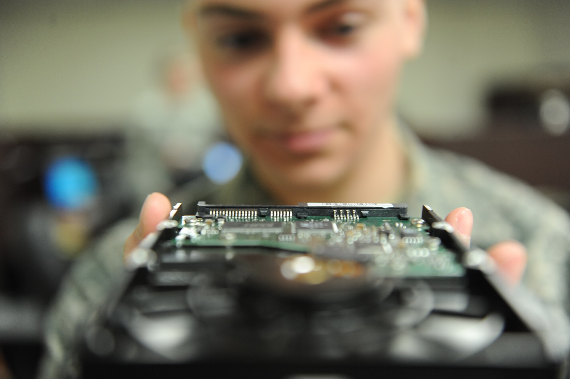 Airman 1st Class Nicholas Billings, client systems technicians with the Minot Air Force Base 5th Communications Squadron, examines a computer’s hard drive at the 5th CS building Jan. 22, 2014. Billings and the Airmen he works with are essential to the mission through their support. (U.S. Air Force photo/Airman 1st Class Lauren Pitts)