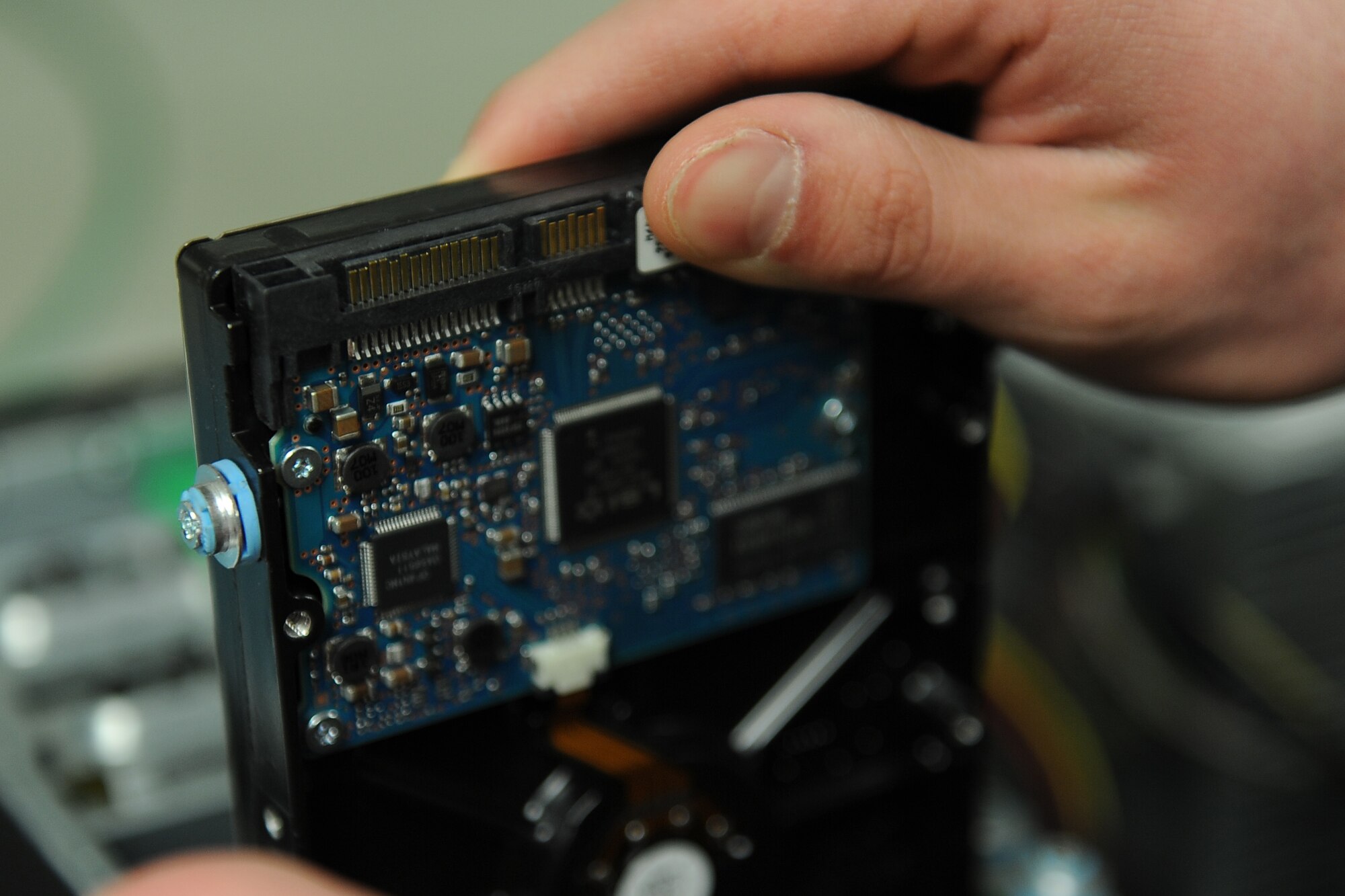 An Airman with the 5th Communications Squadron examines a hard drive at the 5th CS building at Minot Air Force Base Jan. 22, 2014. The support and maintenance delivered by the 5th CS is essential to base wide communication and supporting the mission. 
