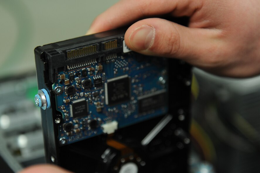 An Airman with the 5th Communications Squadron examines a hard drive at the 5th CS building at Minot Air Force Base Jan. 22, 2014. The support and maintenance delivered by the 5th CS is essential to base wide communication and supporting the mission. 