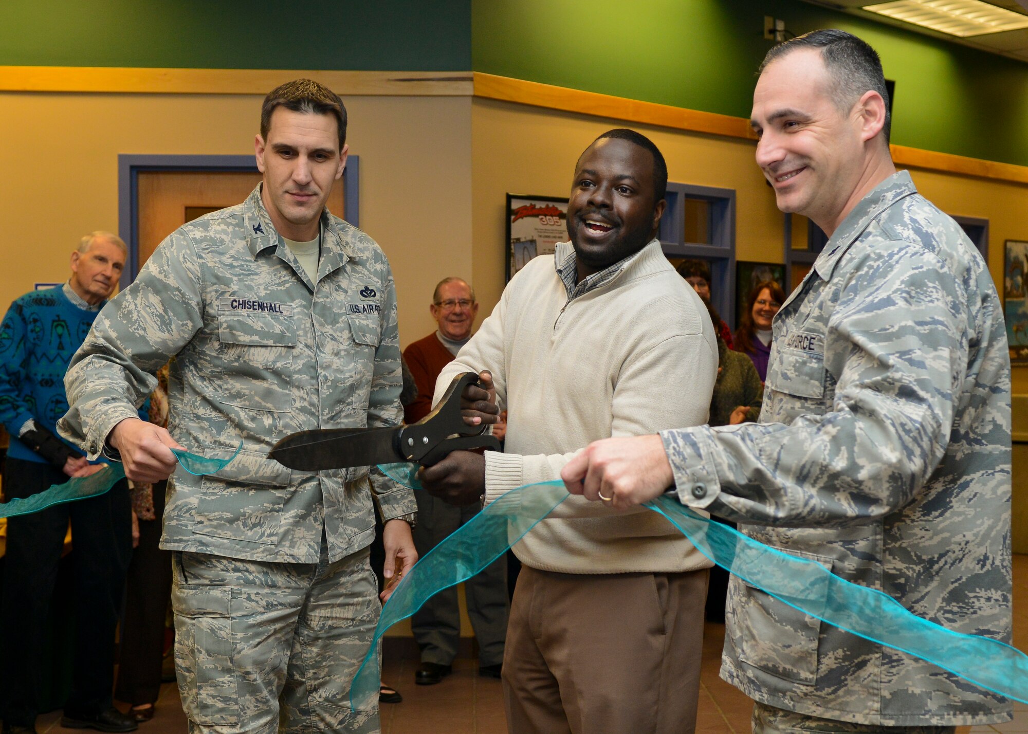 U.S. Air Force Col. David Chisenhall, 633rd Mission Support Group commander, James Murrell, Langley Community Programs director, and Lt. Col. Charles Evitts, 633rd Contracting Squadron commander, perform the ribbon-cutting ceremony at the Community Commons at Langley Air Force Base, Va., Jan. 24, 2014. The newly renovated building will feature the Airman’s Attic, Thrift Shop, Information, Tickets and Travel and Heidi’s Cinderella Closet. (U.S. Air Force photo by Airman 1st Class Victoria H. Taylor/Released)