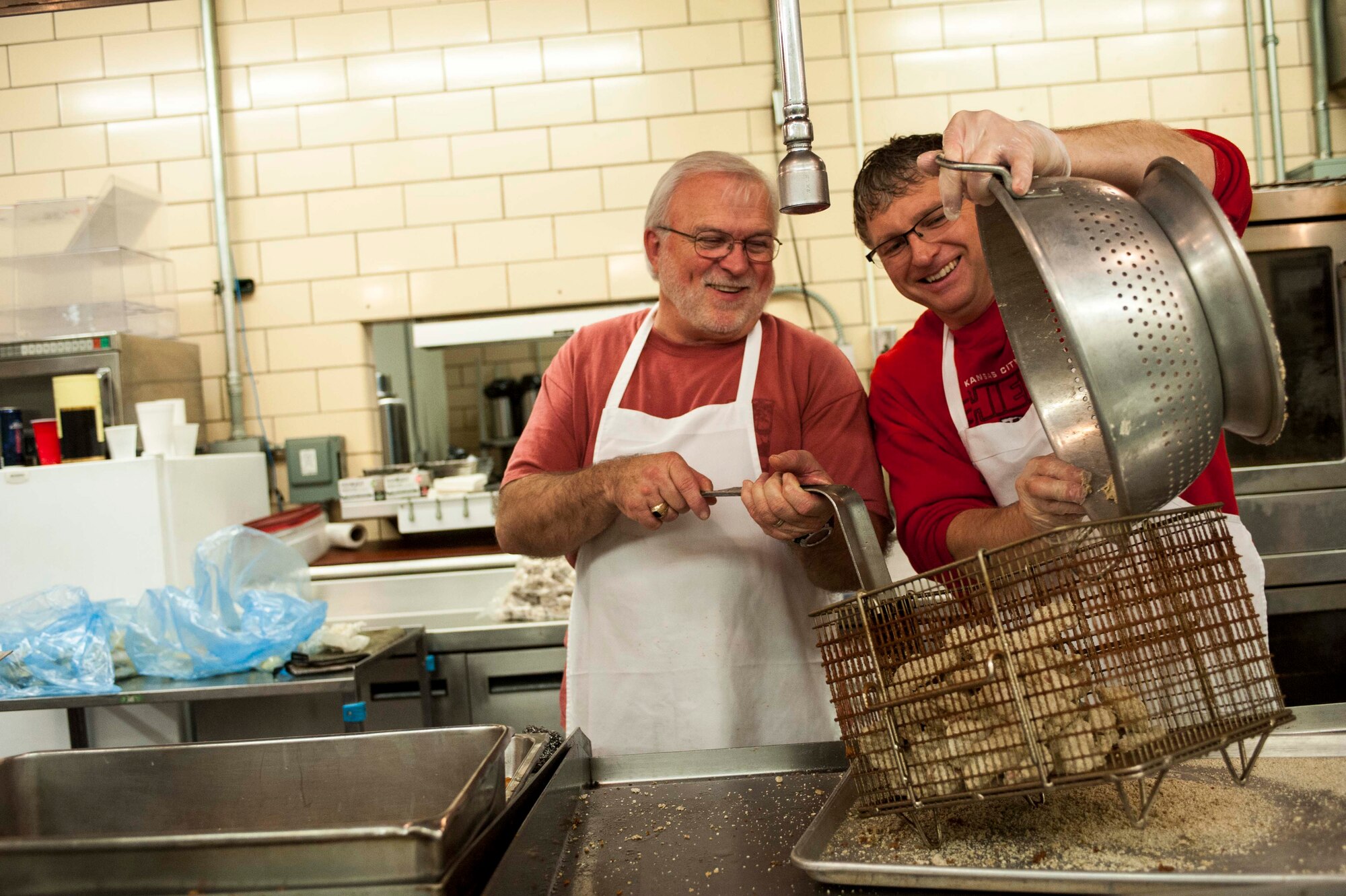 (right to left) David Bussard, is assisted by a member of the Minot Military Affairs Committee with cooking wild game for the 49th Annual Sportsman’s Feed hosted at the Jimmy Doolittle Center, Minot Air Force Base, N.D., Jan. 19, 2014. The event started as a way for hunters in the local community and base leadership who shared their passion for the outdoors to meet and share fellowship in the 1950’s. (U.S. Air Force photo/Senior Airman Stephanie Sauberan) 