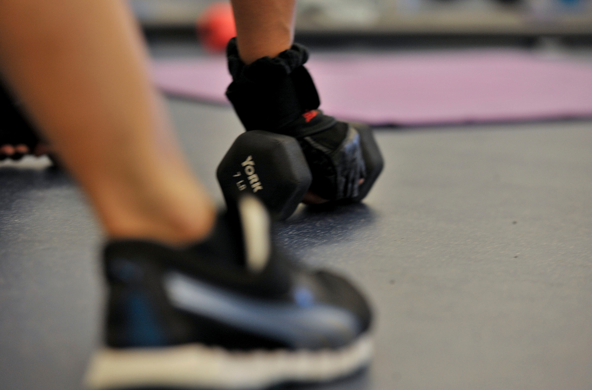 Luz Toliver, Aderholt Gym body sculpt instructor, demonstrates how to use weights during a full body sculpt work out at Hurlburt Field, Fla., Jan. 23, 2014. Toliver suggest beginner’s start these workouts three times a week; two days should be strength workouts and one cardio-based. (U.S. Air Force photo/Airmen 1st Class Andrea Posey)